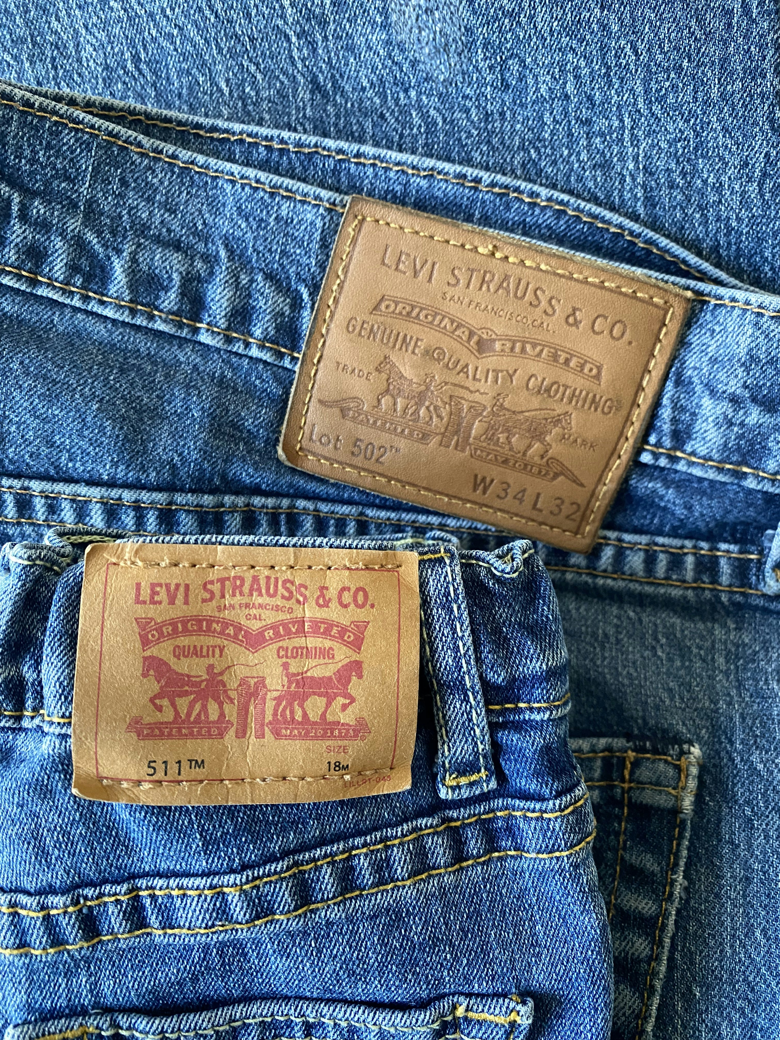 Two pairs of blue levi's jeans with brand patches.