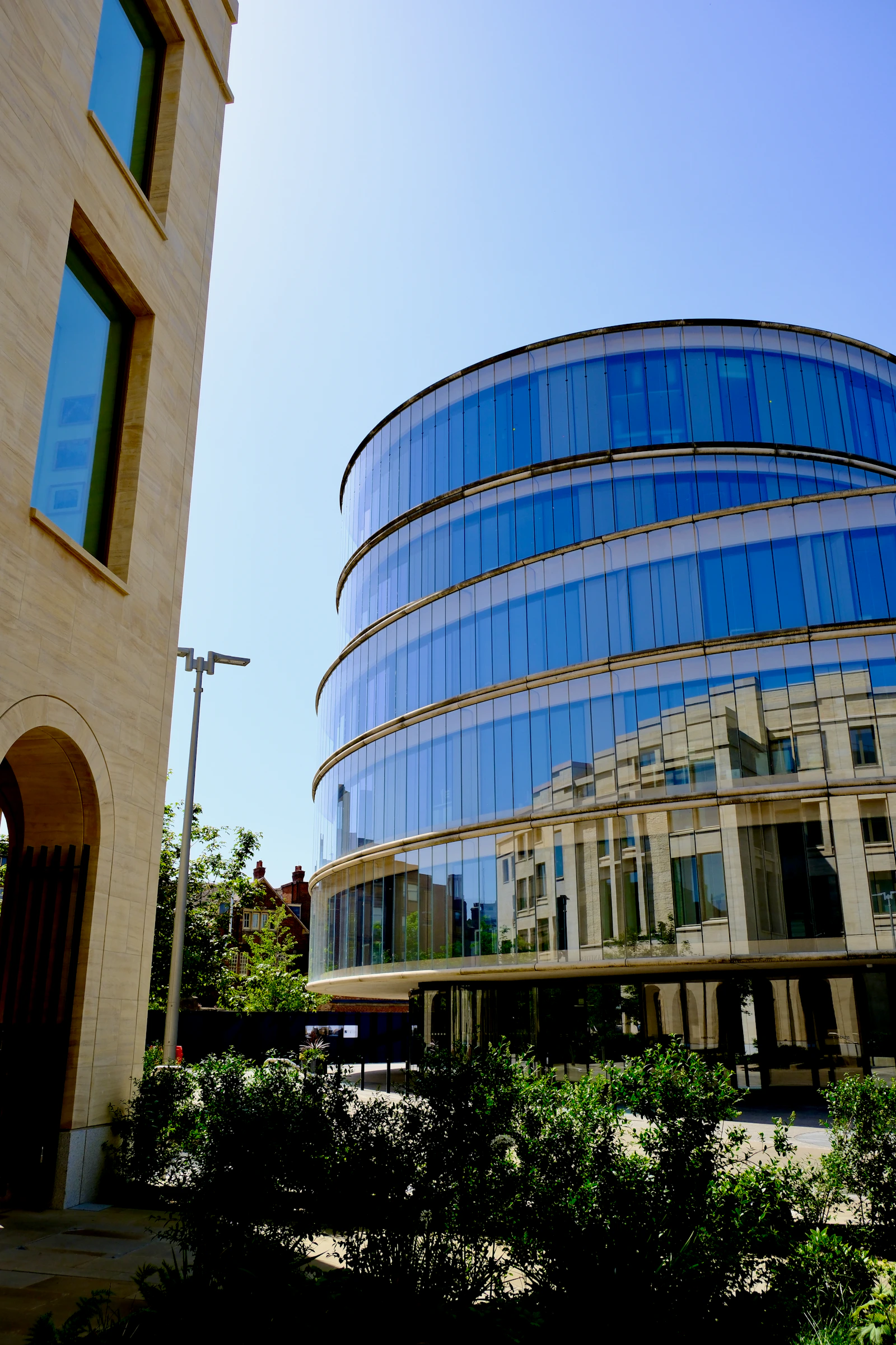 Modern curved glass building beside traditional stone architecture, representing family office evolution