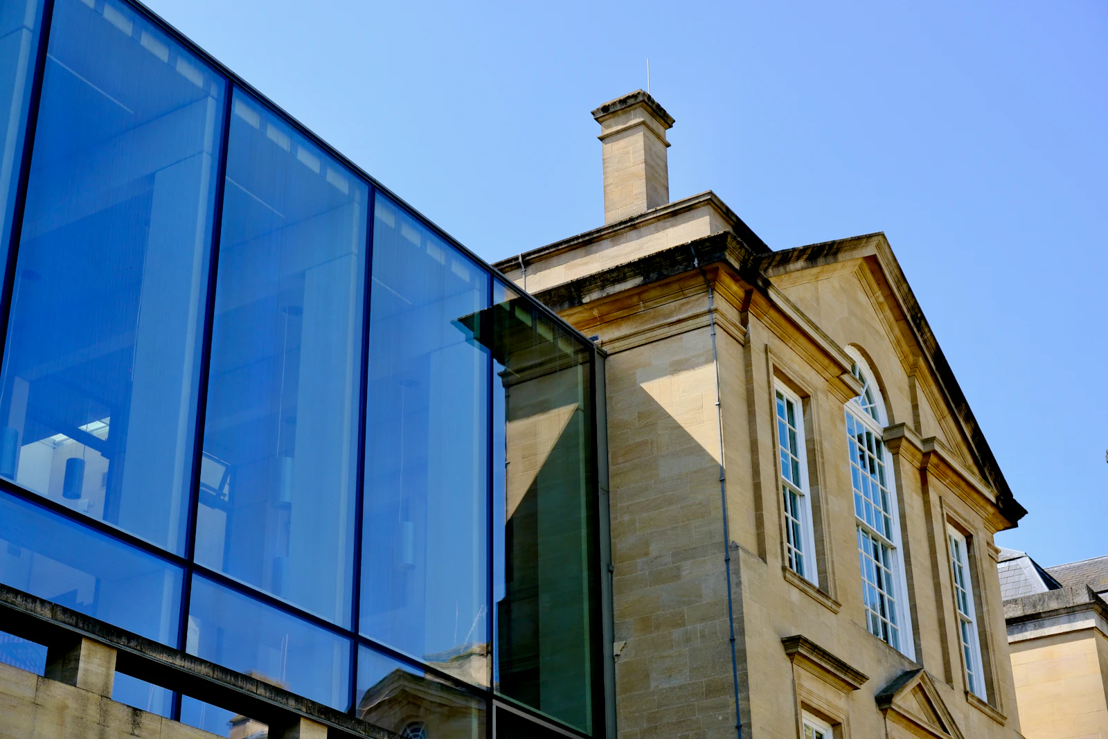 Extension vitrée moderne accolée à une maison en pierre