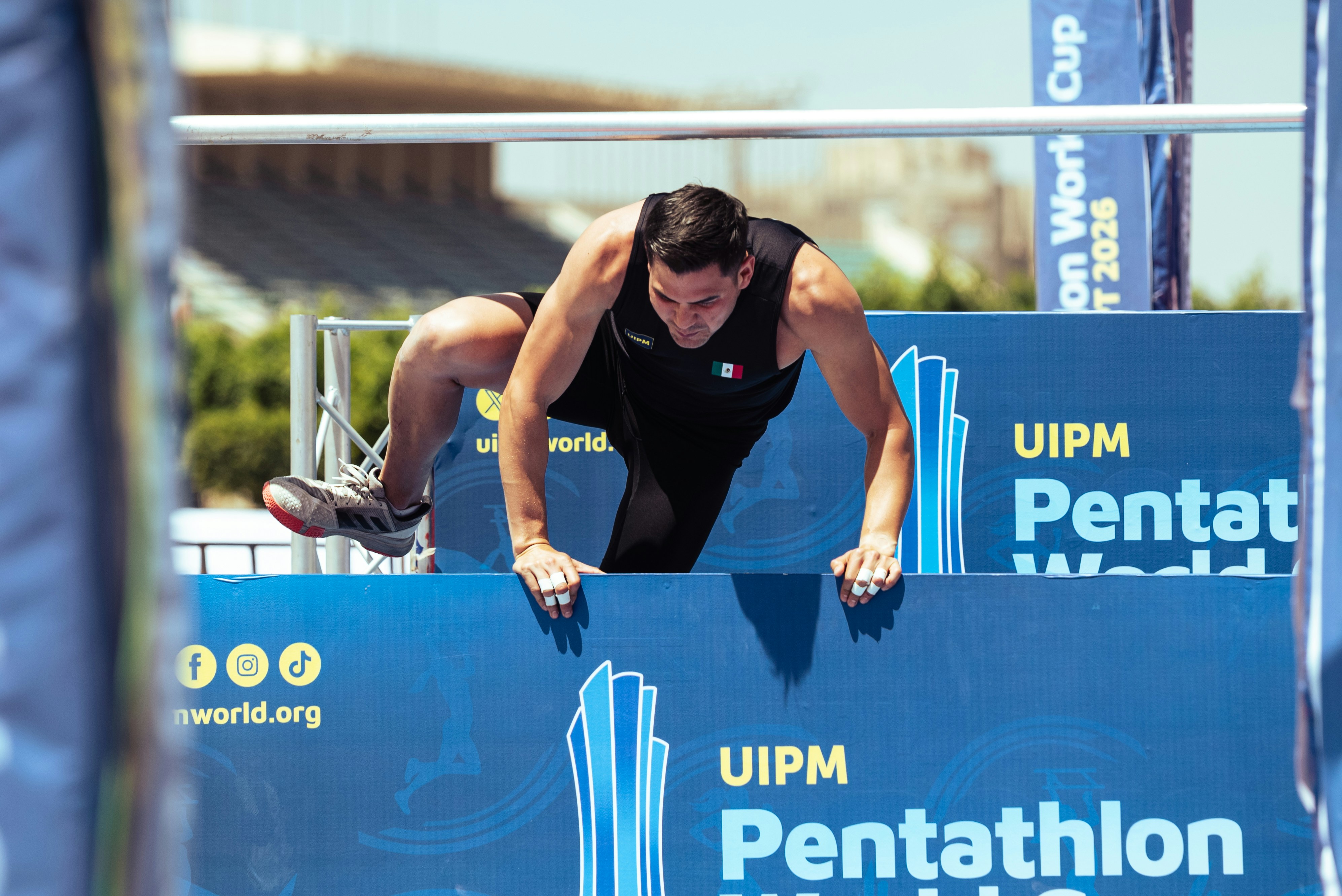 Atlet pentathlon memanjat rintangan biru selama kompetisi.