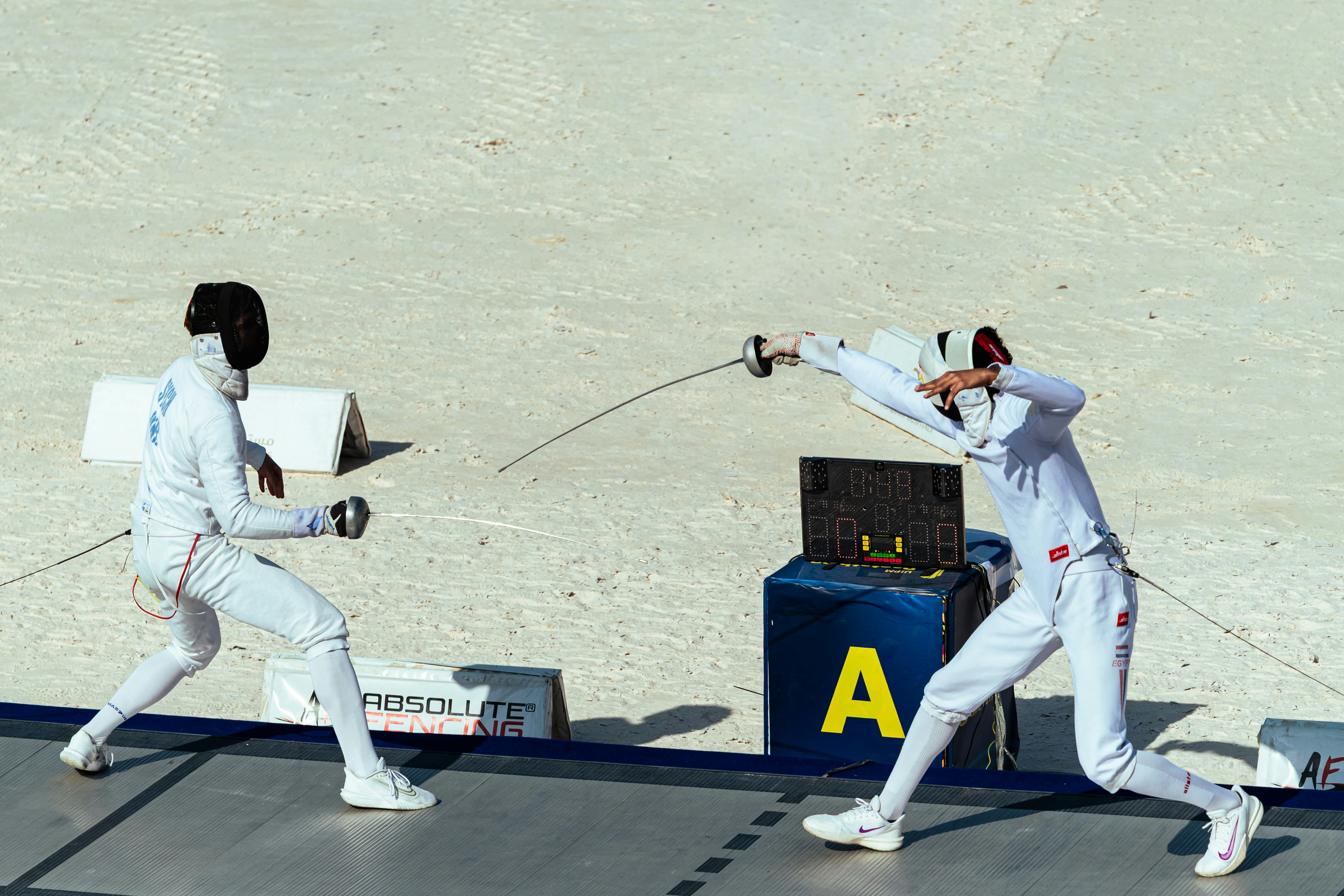 Dos esgrimistas con uniformes blancos se enfrentaron en un duelo de esgrima.