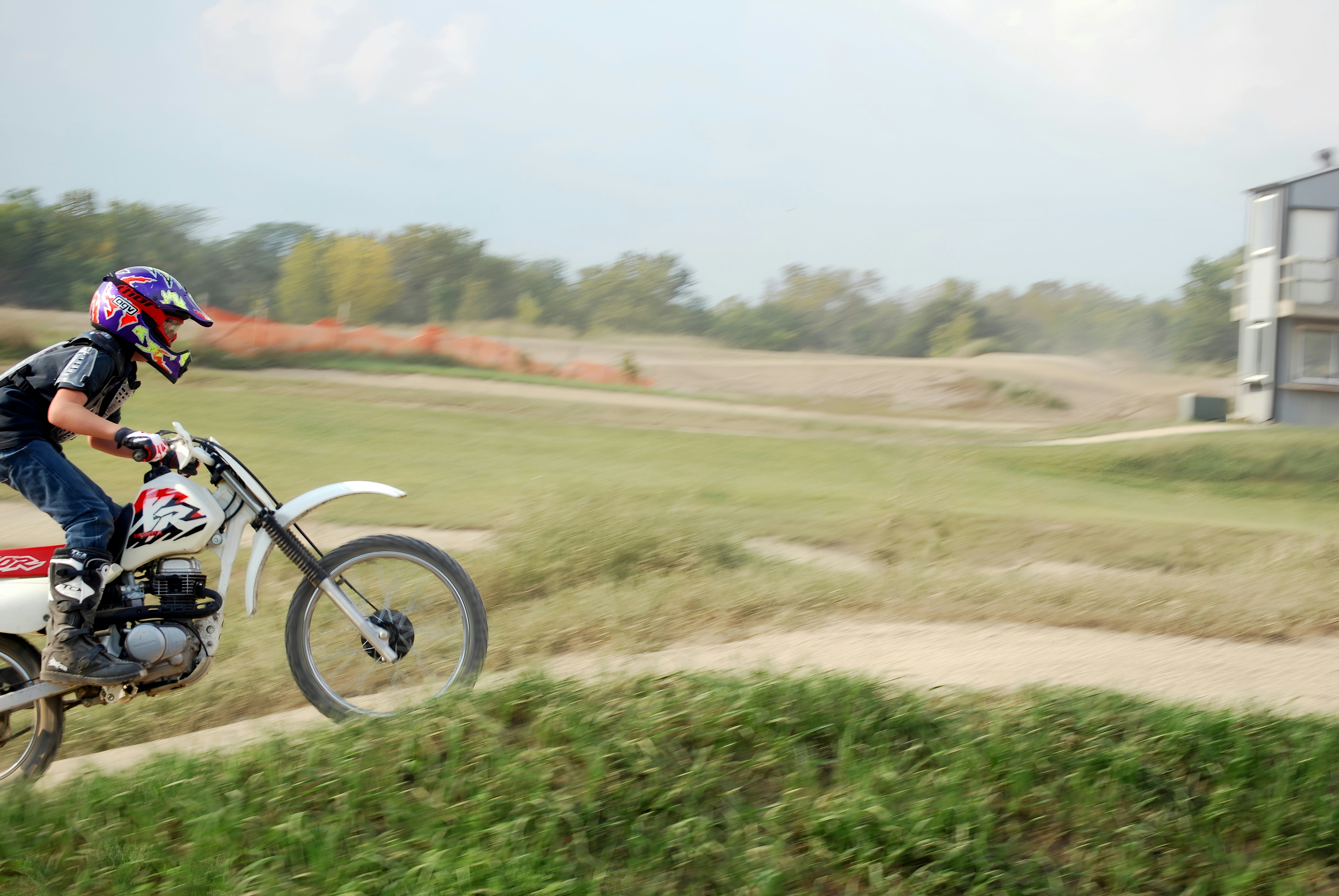 A person rides a dirt bike on an outdoor track.