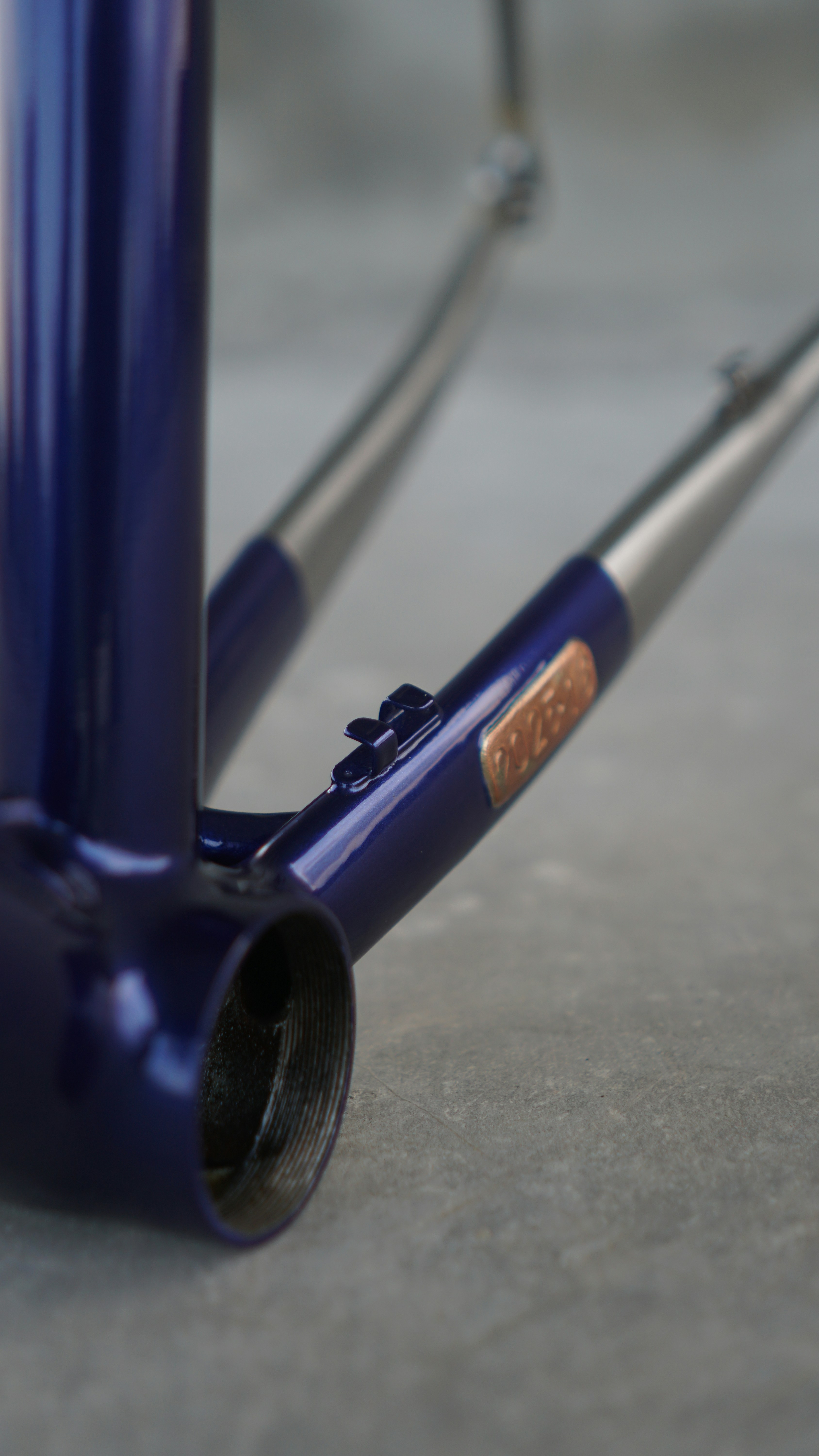 Purple bicycle frame with copper badge and metallic parts