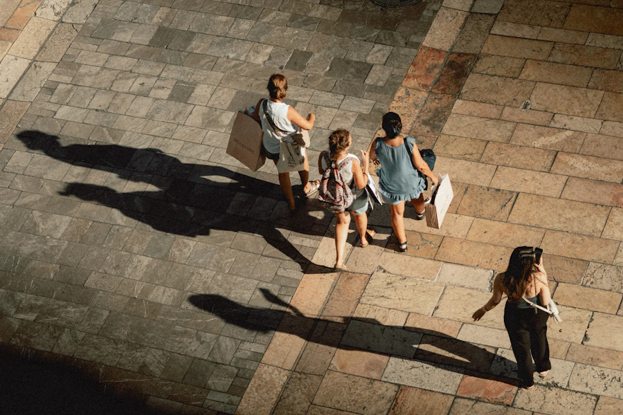 Shoppers with bags on a sunny street in Málaga