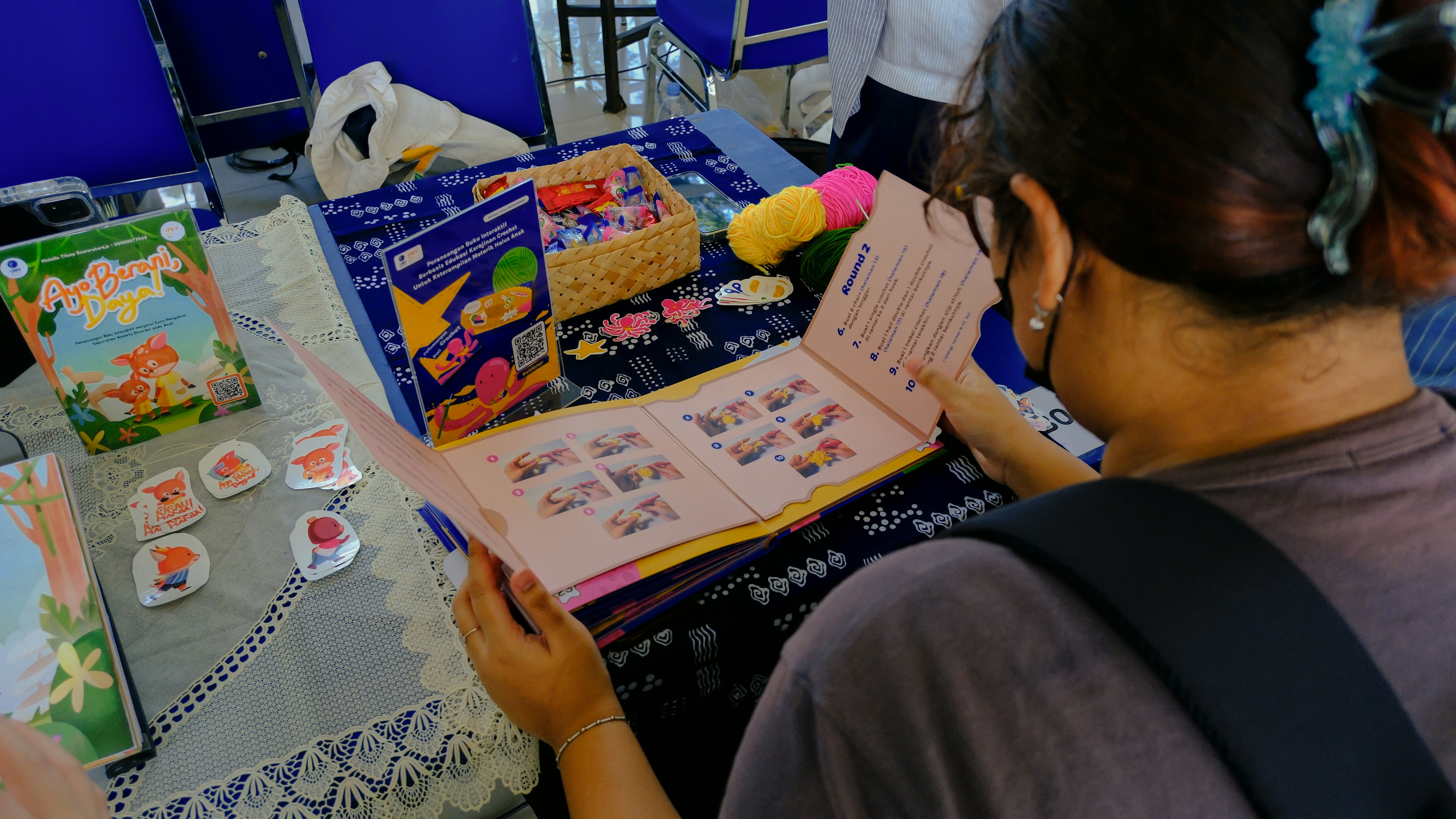 Uma pessoa examinando um livro aberto em uma barraca de mercado.