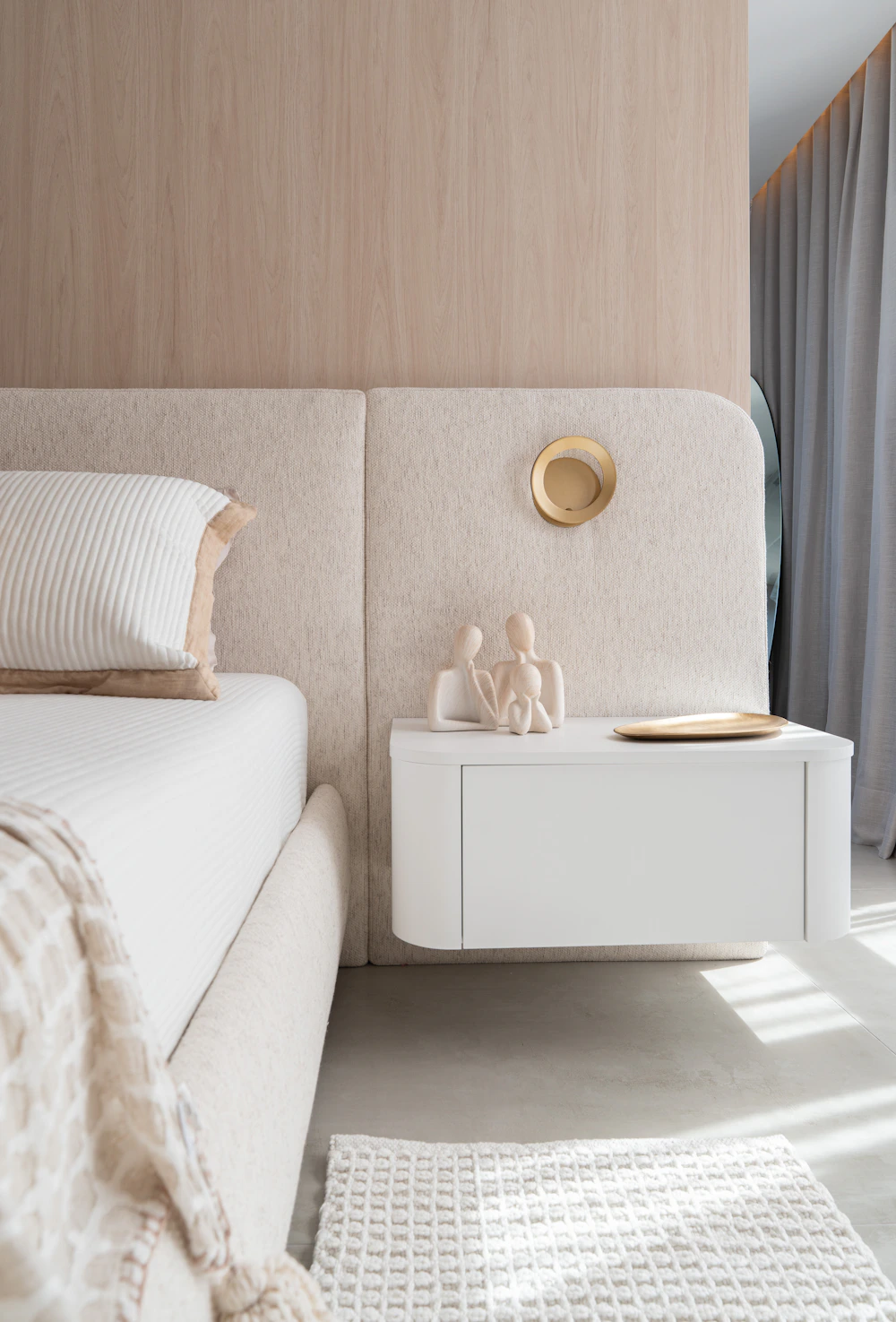 Peaceful contemporary bedroom featuring a neutral upholstered bed and minimalist bedside furniture