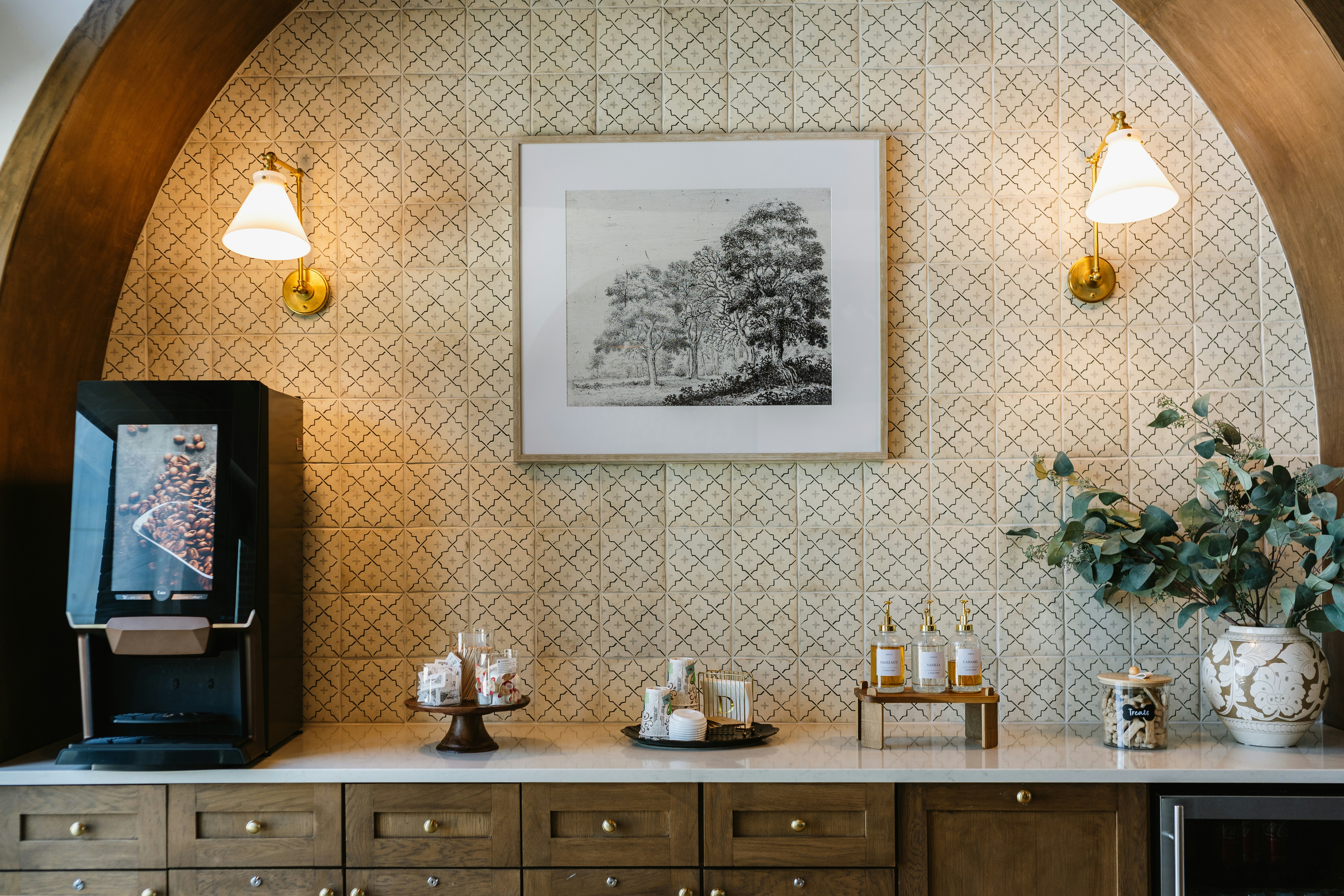 Elegant coffee station with a machine, decor, and framed art.
