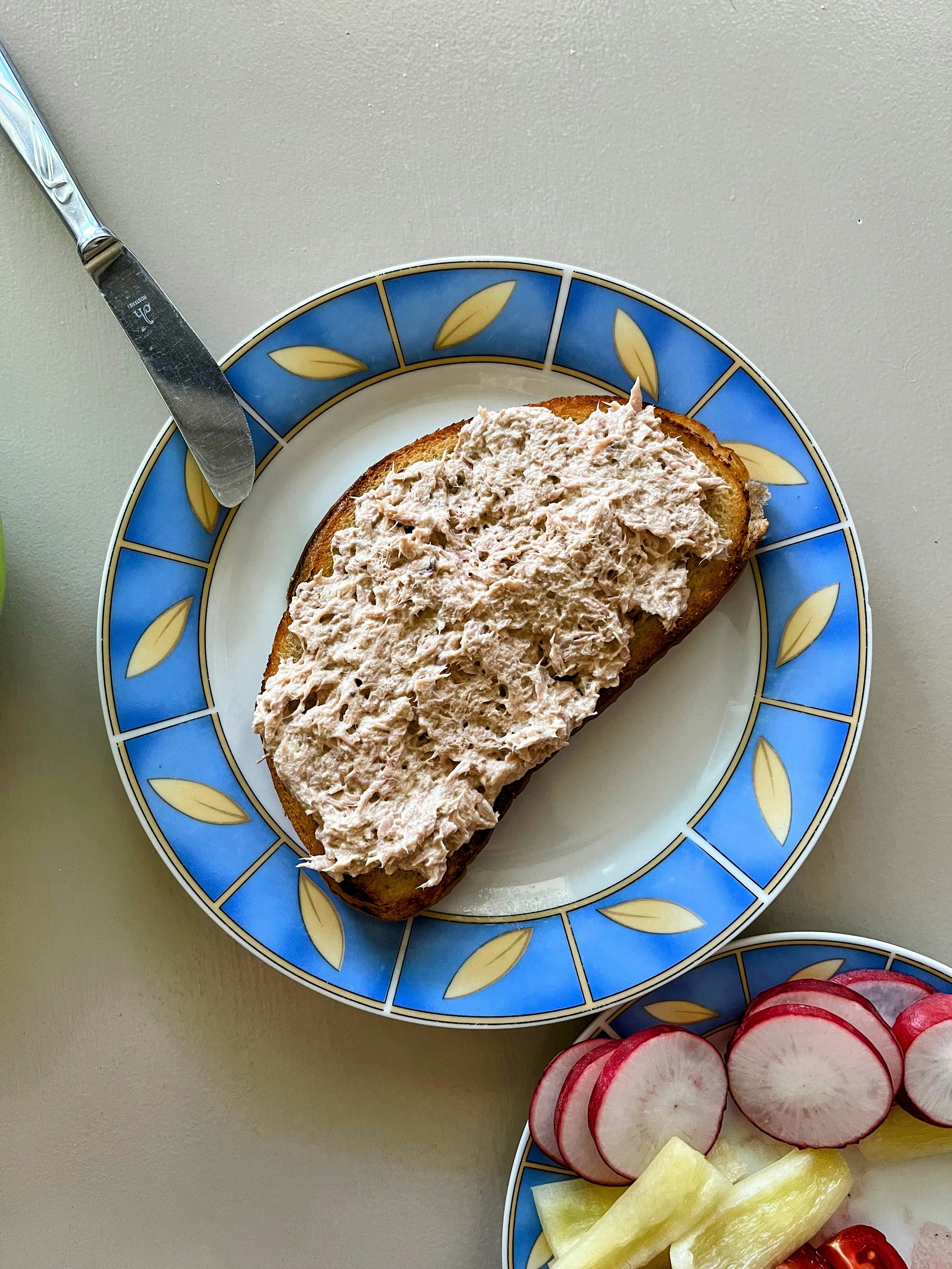Tuna salad on toast with sliced radishes.