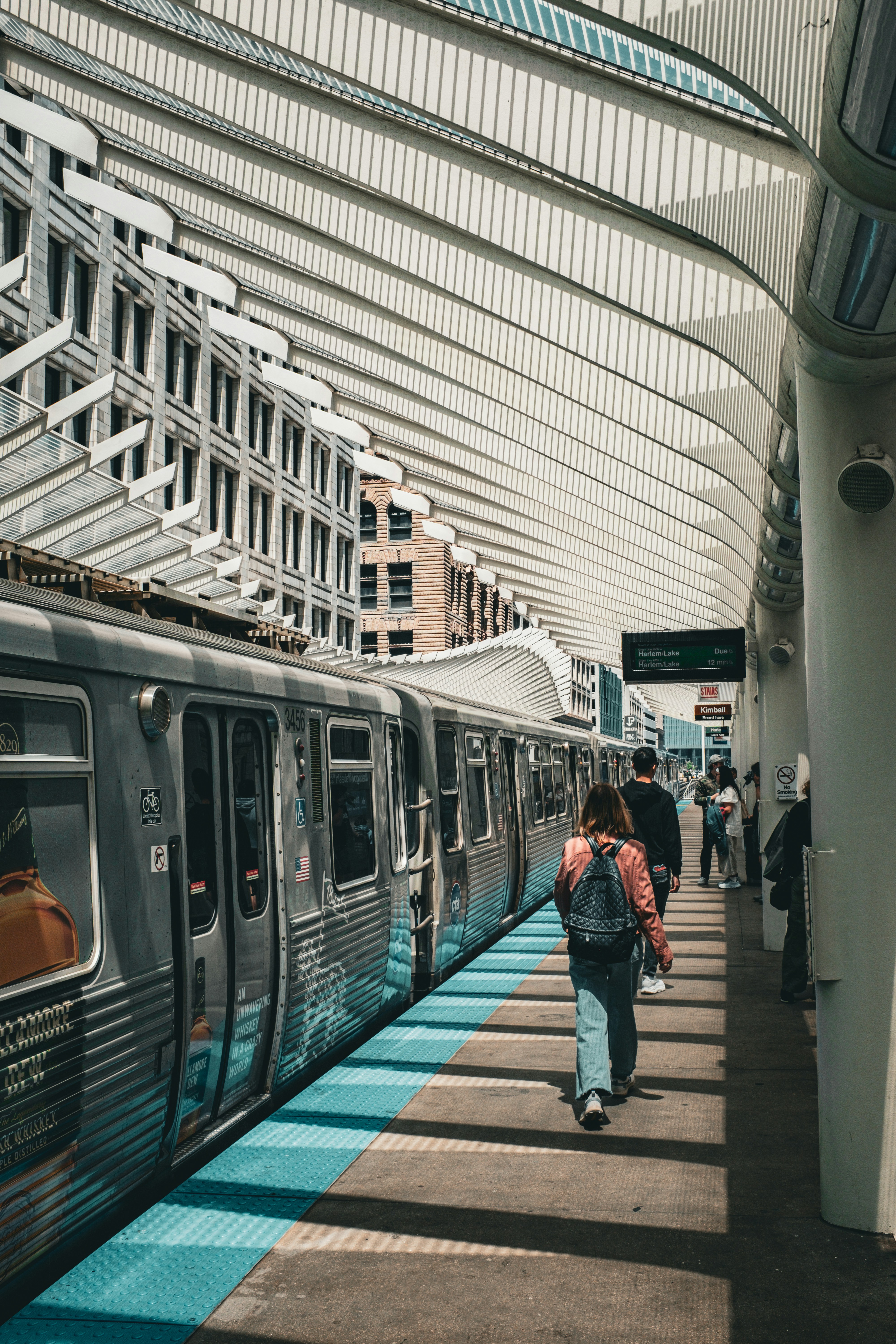 Gare urbaine où des gens marchent le long d’un train garé.