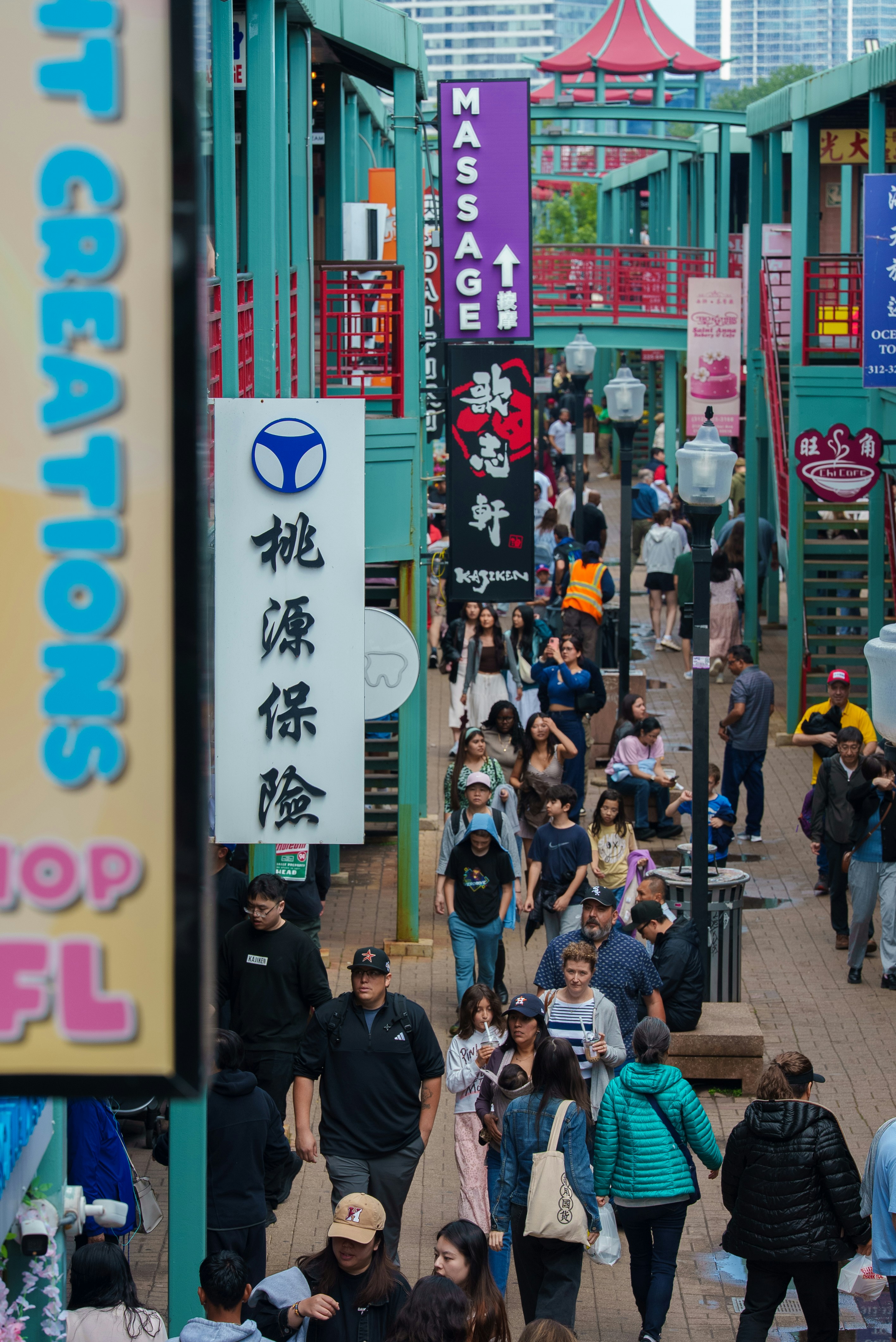 Crowds of people stroll through a vibrant asian-themed marketplace.