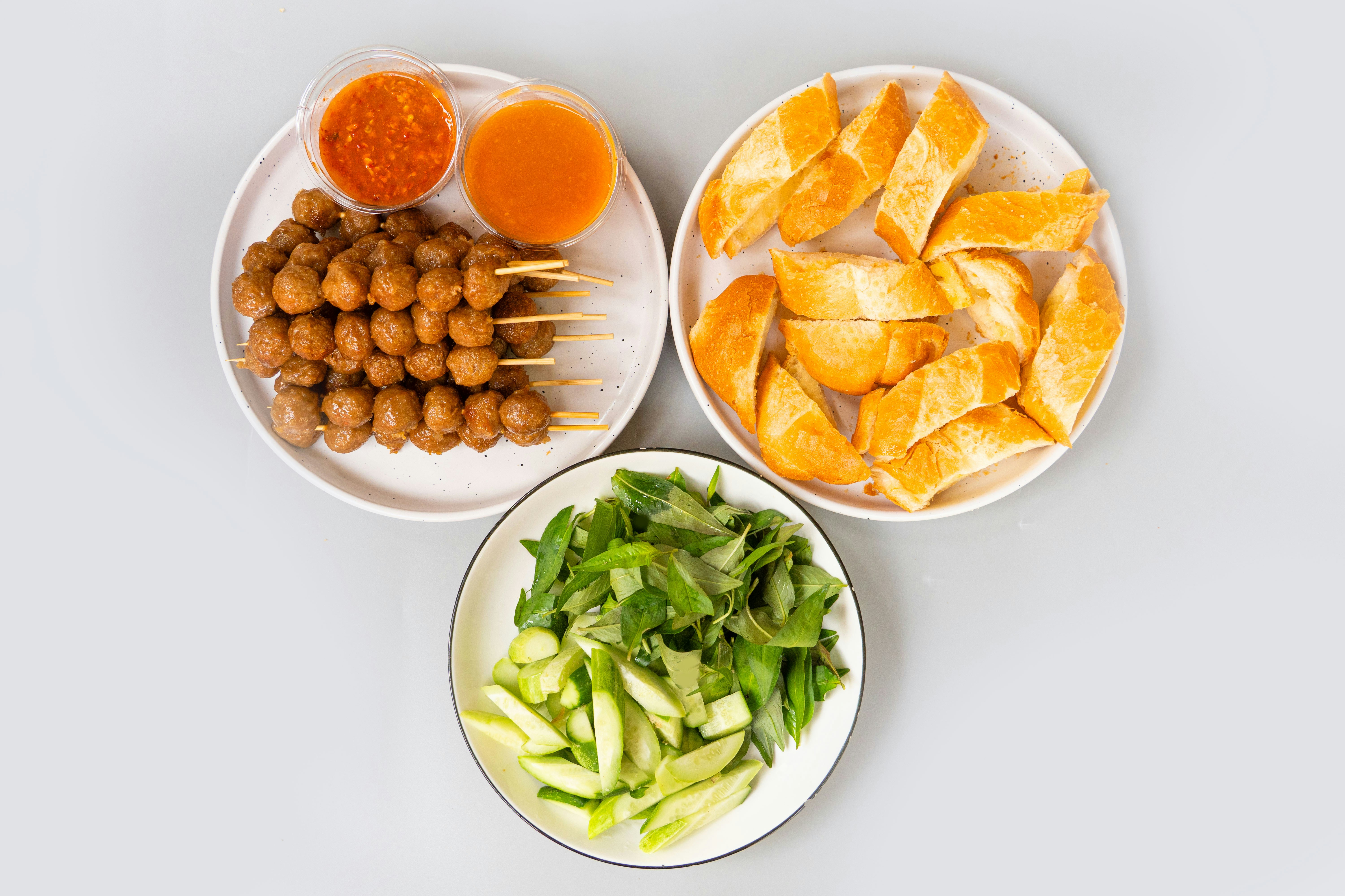 Skewered meatballs, fried fish cakes, and fresh vegetables with sauce