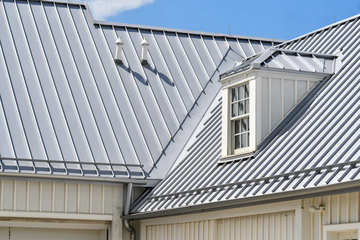 Gray standing-seam metal roof on a white house