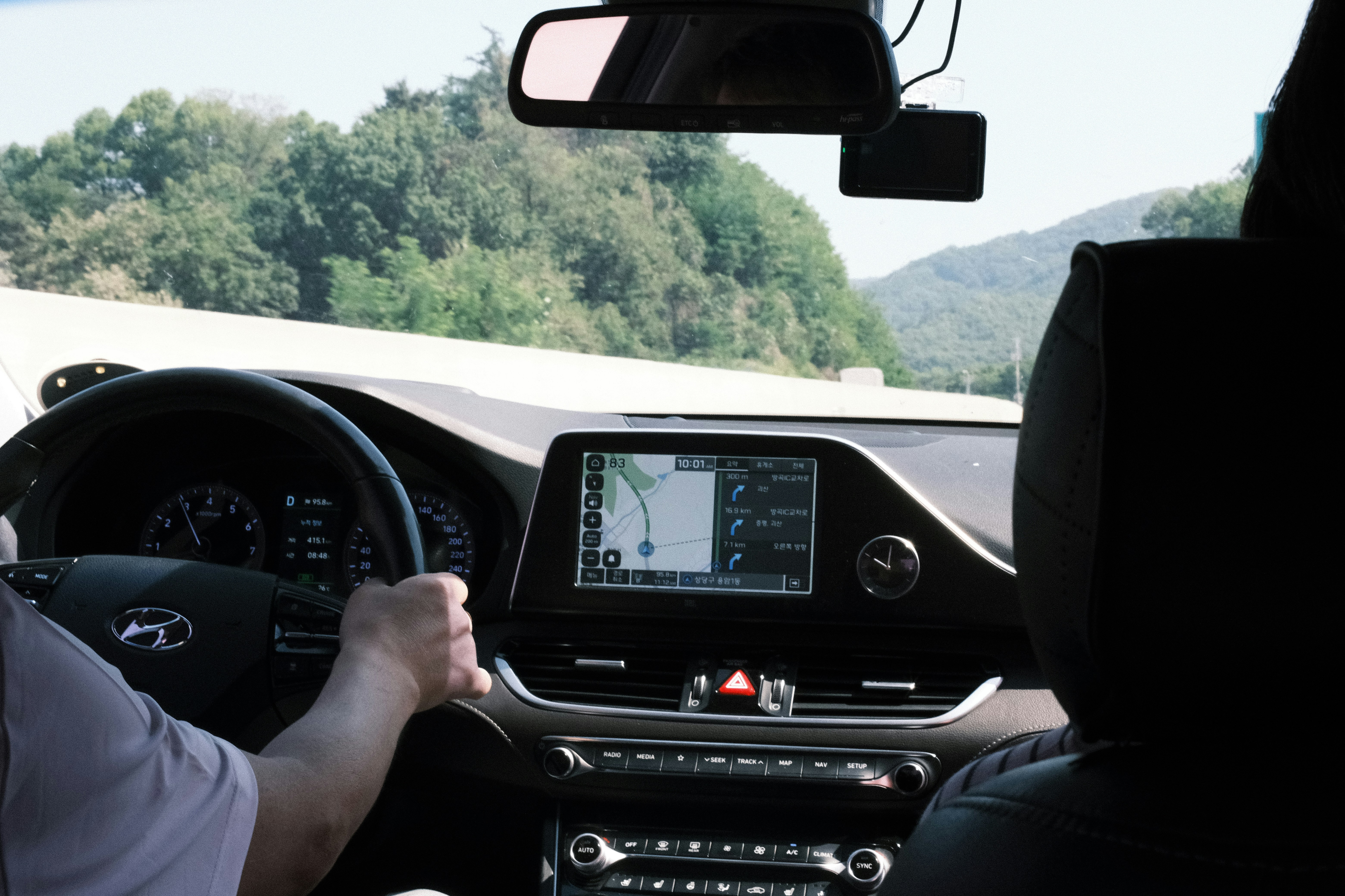 車を運転し、ダッシュボードとナビゲーション画面、前方の道路。