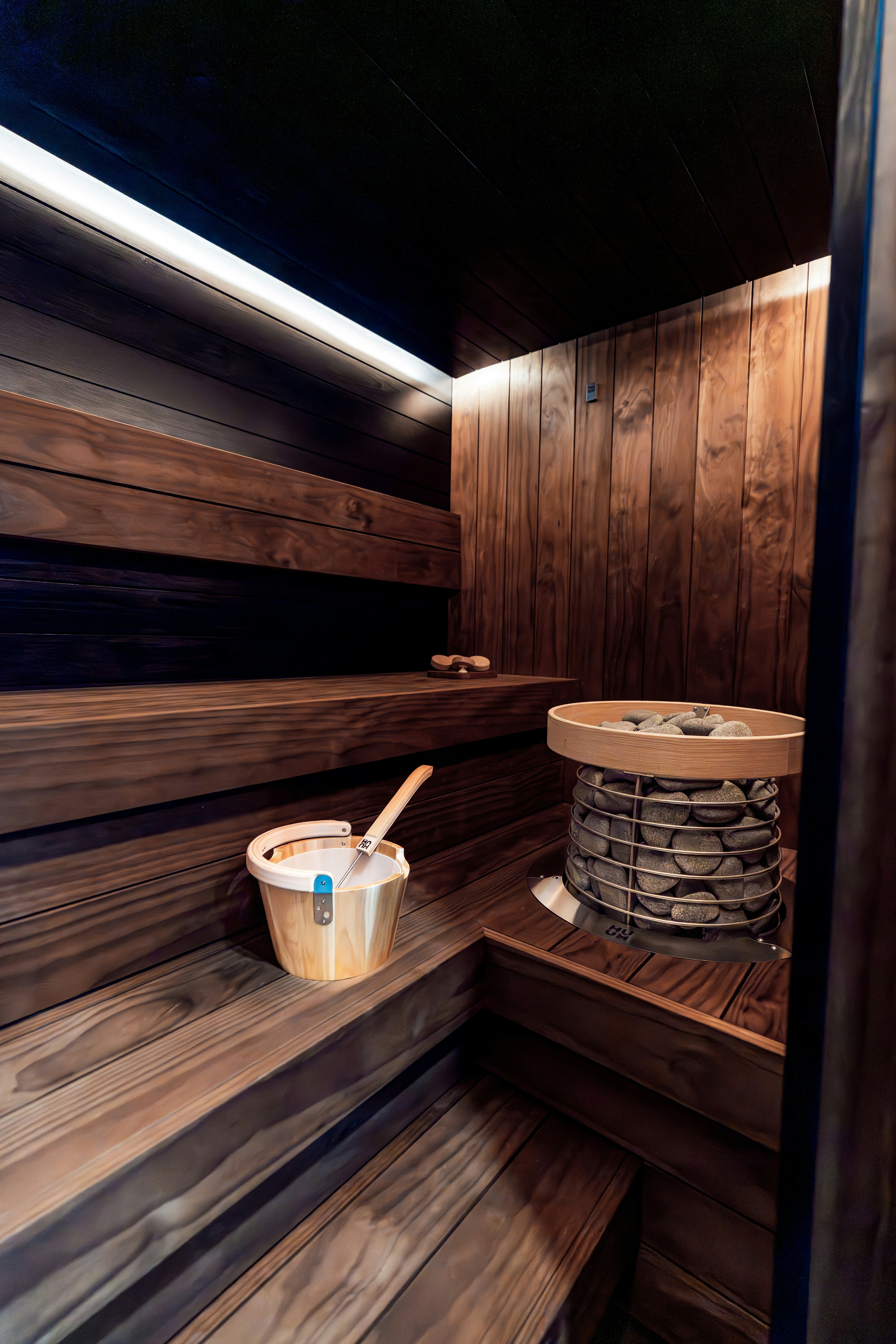 Un intérieur douillet de sauna en bois avec des bancs et un chauffage.