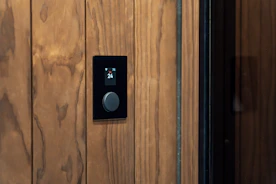 Modern black control panel with a knob on wood.