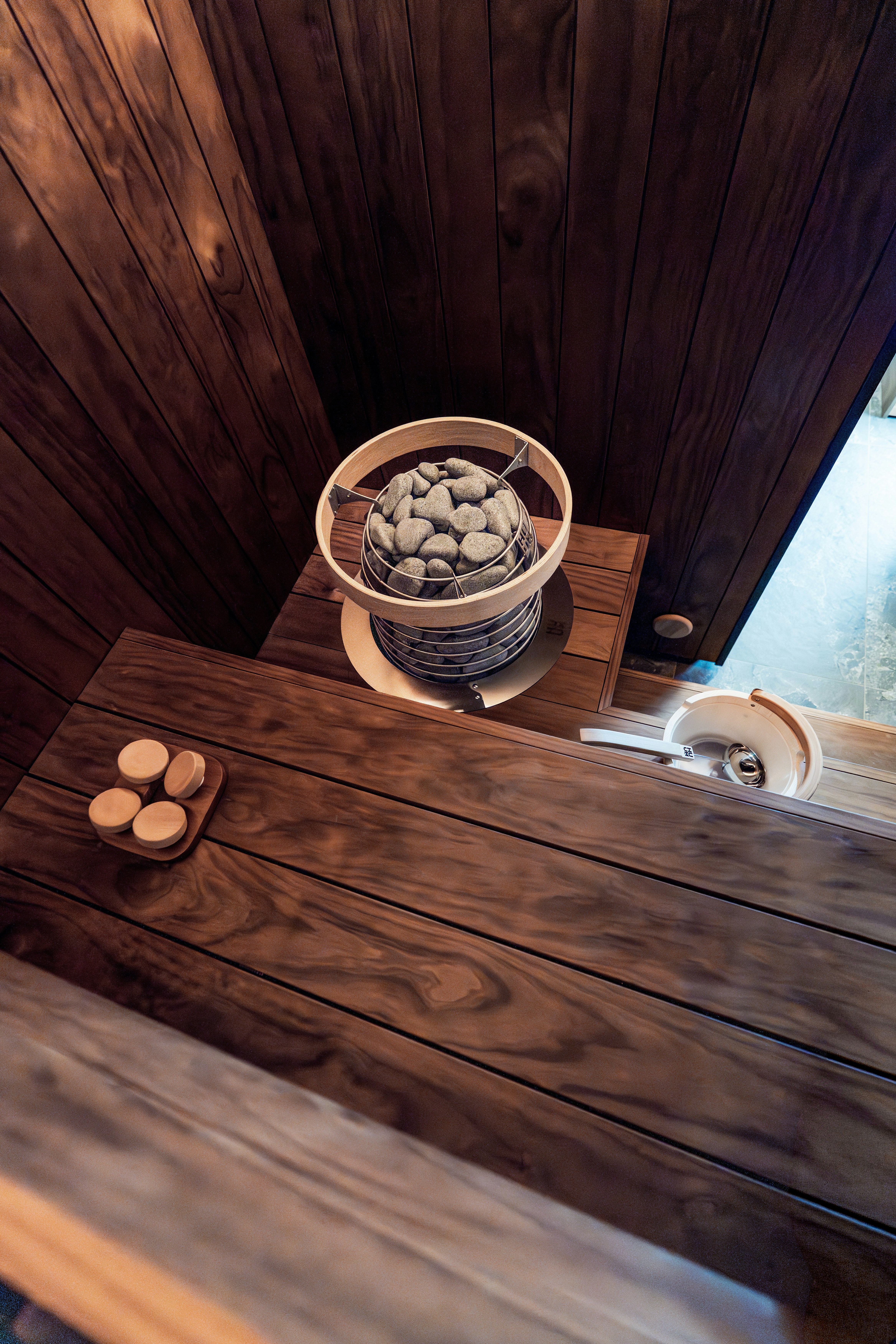 Intérieur chaleureux de sauna en bois avec chauffage et accessoires traditionnels.