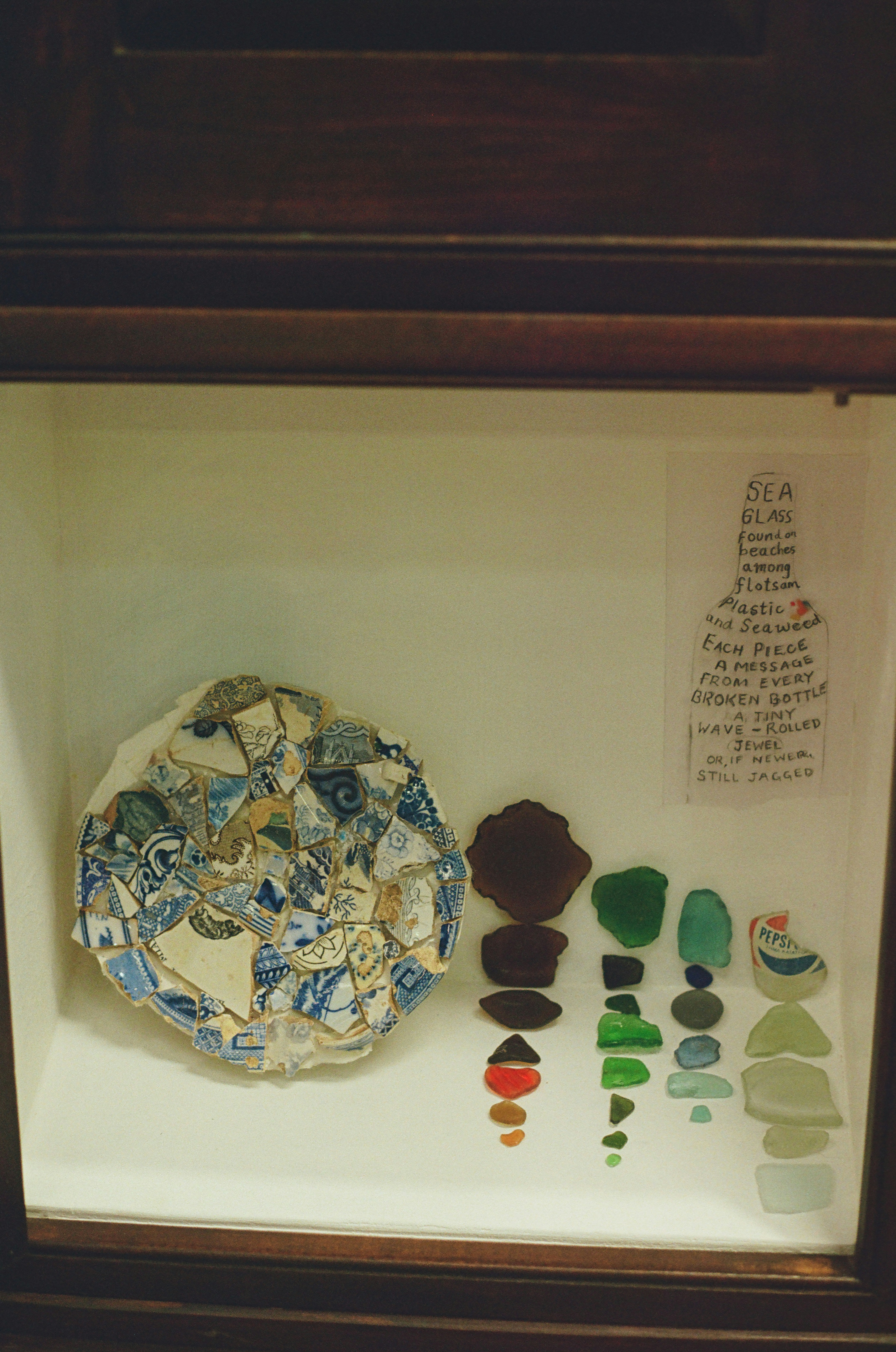 A display of broken pottery shards and colorful sea glass.