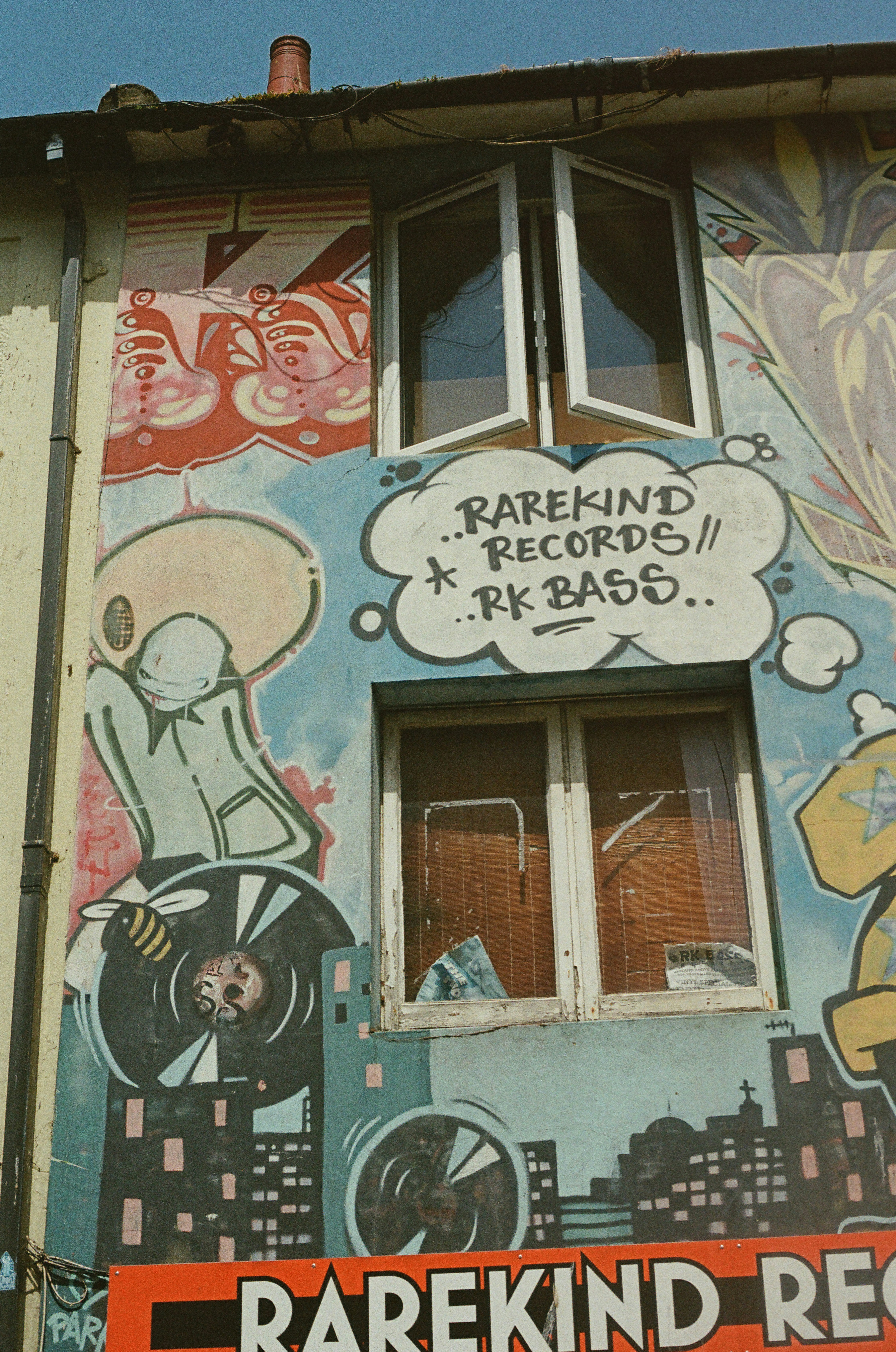 Stadtgebäudefassade geschmückt mit bunten "Rarekind Records"-Graffiti.