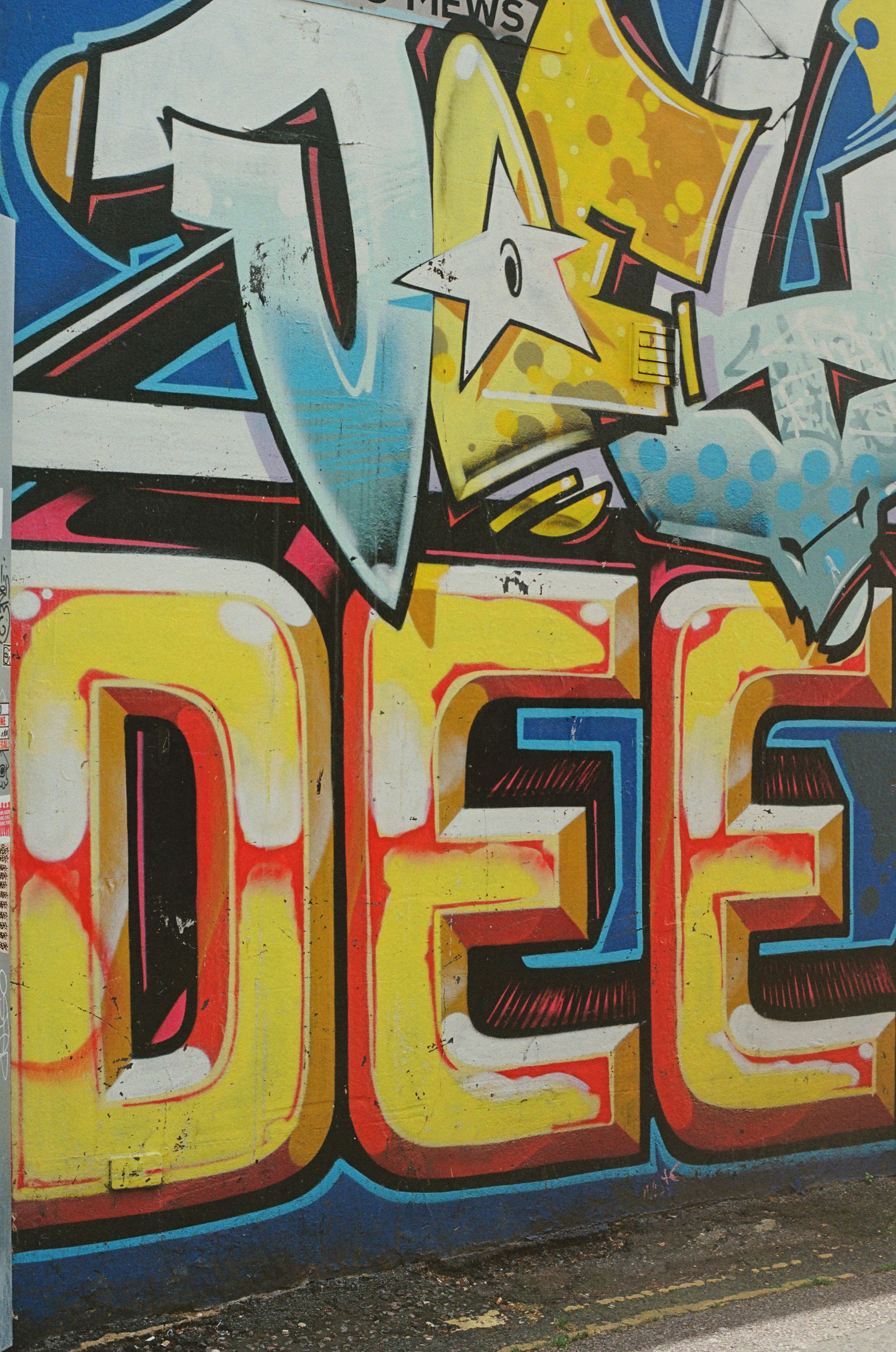 Colorful street art graffiti with stylized letters on a wall.