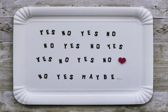 White tray with "yes no" pattern, red heart, and "maybe...".