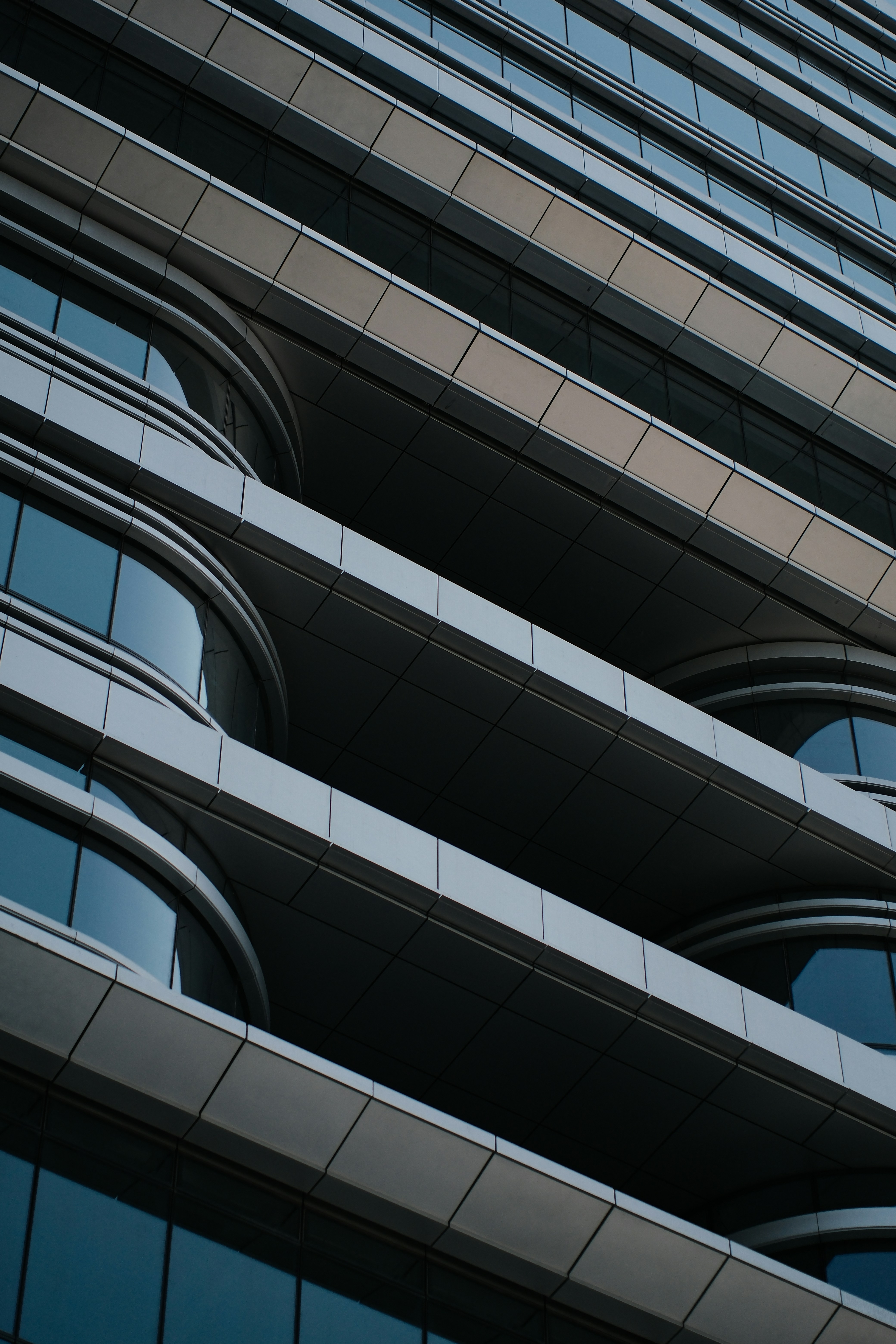 Modern building facade with curved windows and horizontal lines.
