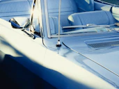 A vintage blue convertible car with light blue interior
