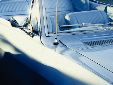 A vintage blue convertible car with light blue interior
