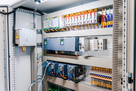 Open industrial electrical control panel with wires and modules