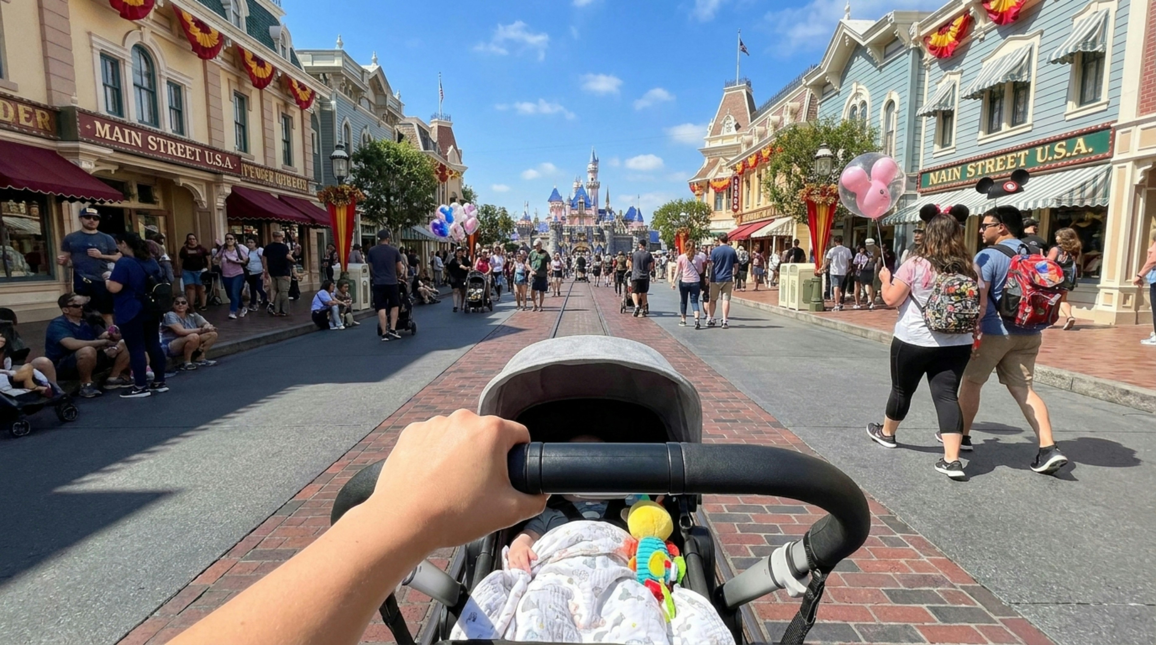 Pushing a baby stroller down a busy street on a warm day
