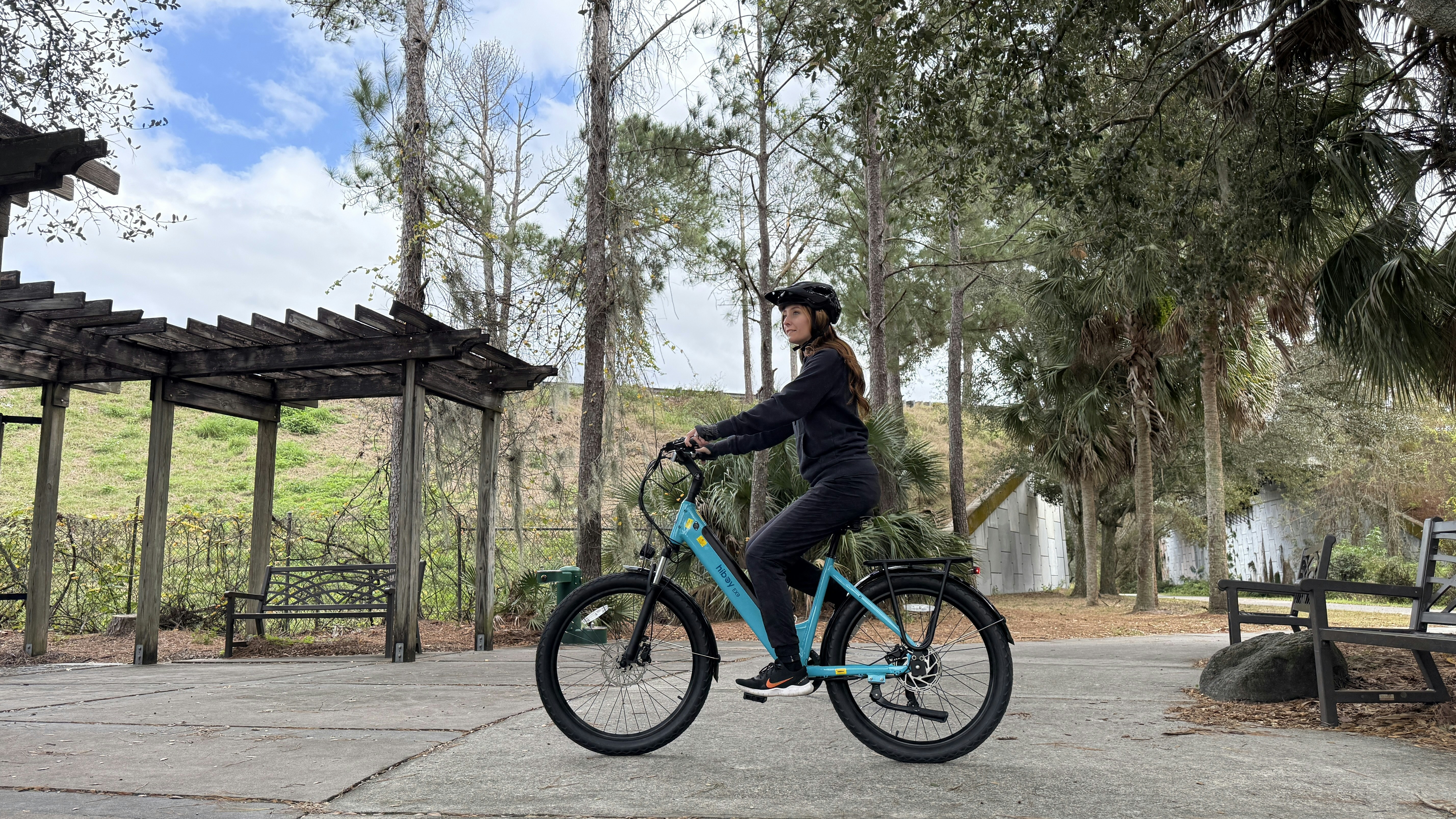 A woman riding a blue bicycle in a park