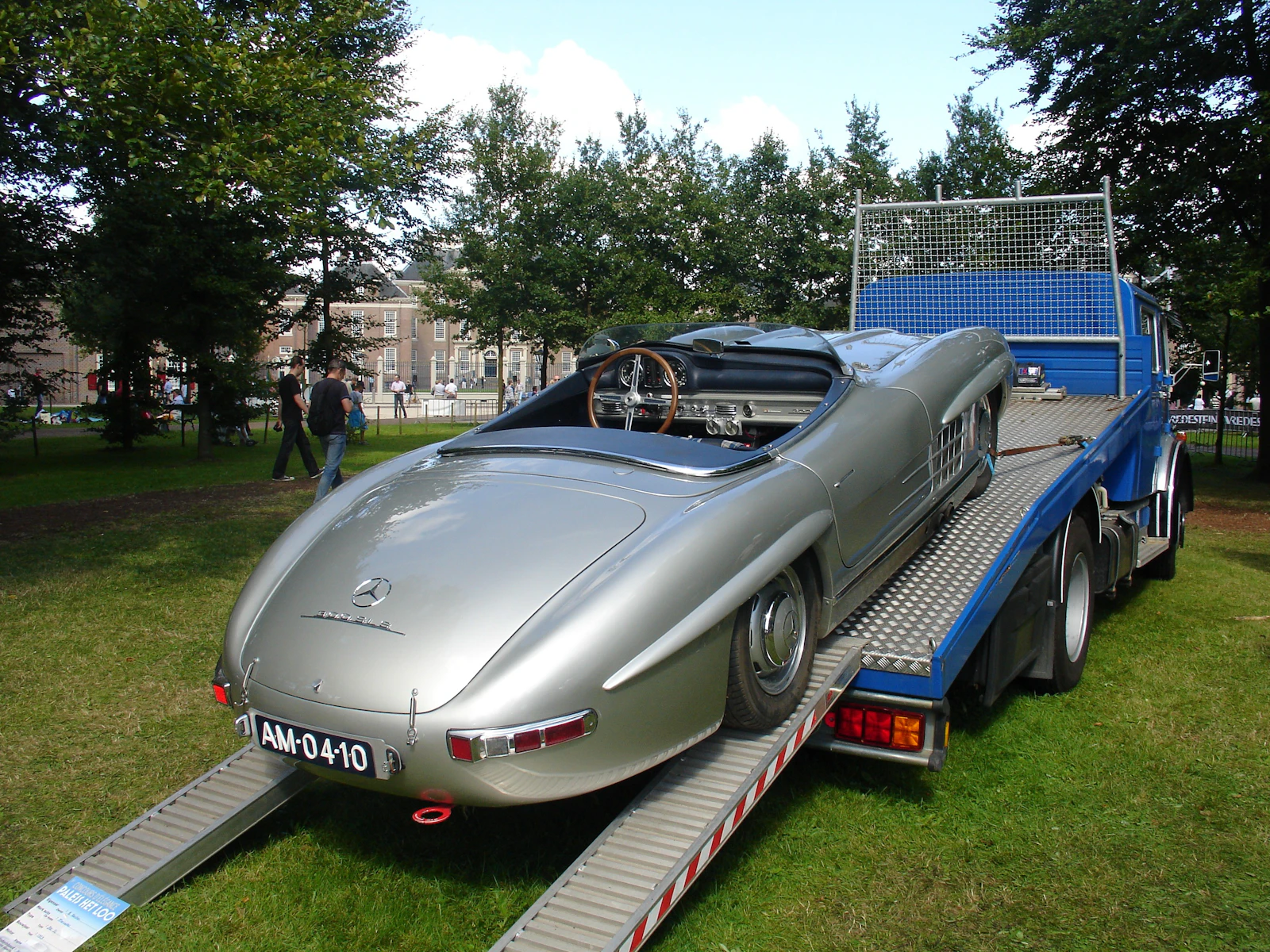 Classic silver sports car being transported on a flatbed