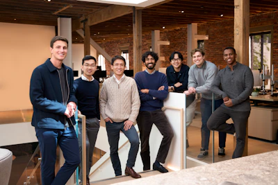 Seven diverse men standing together in a modern office