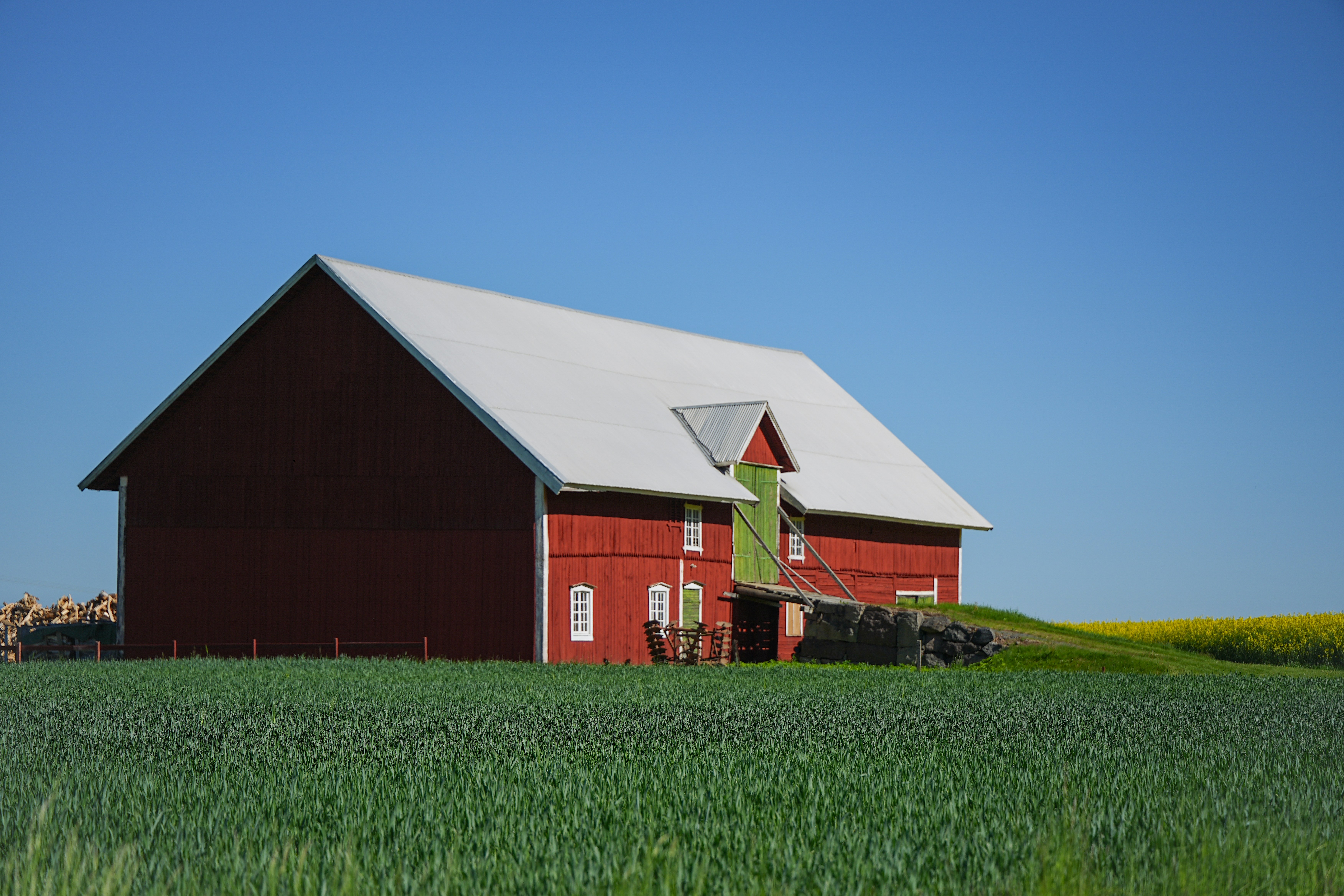 Classic red barn in a green field under blue sky.