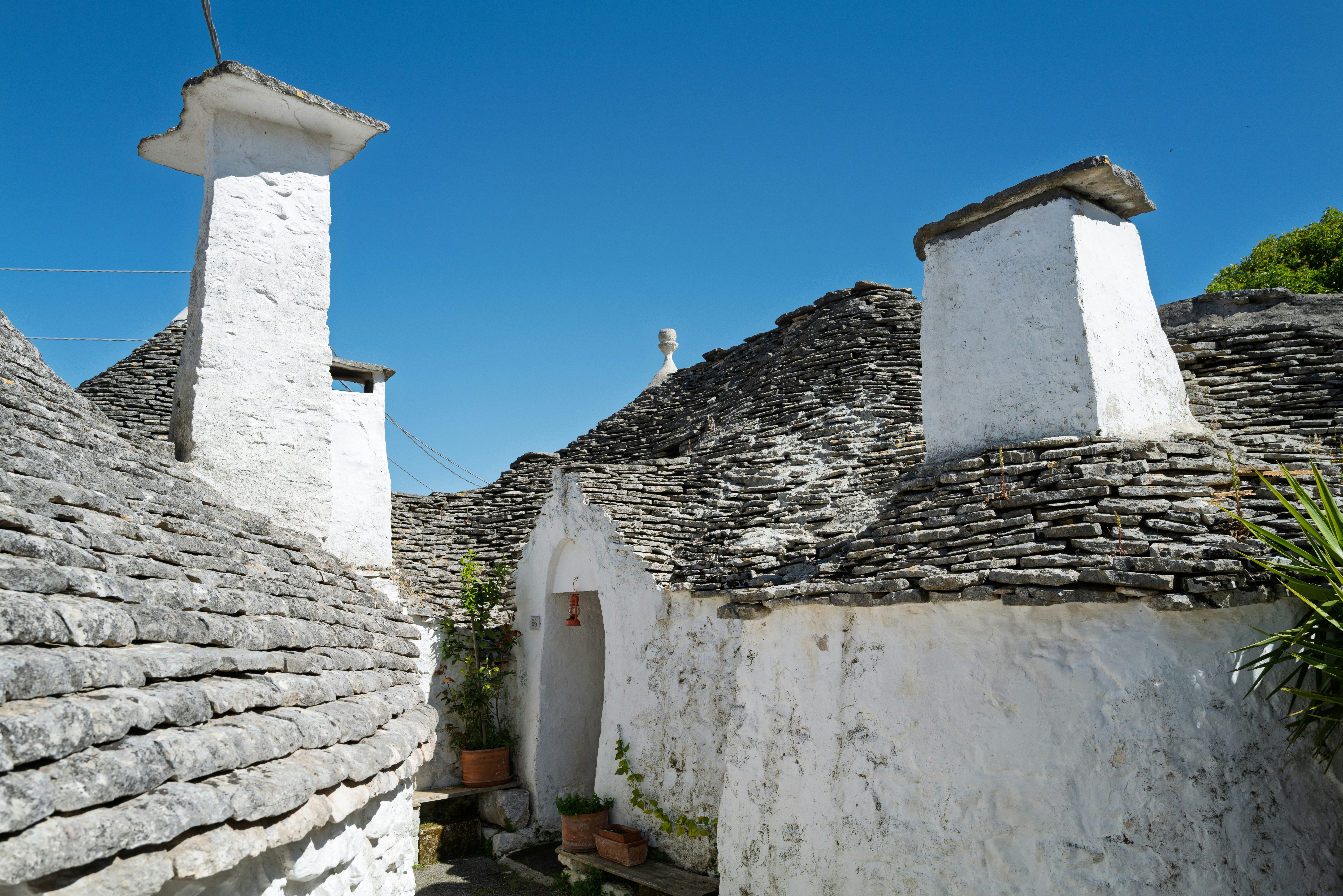 Charming trulli houses with conical roofs and white chimneys.
