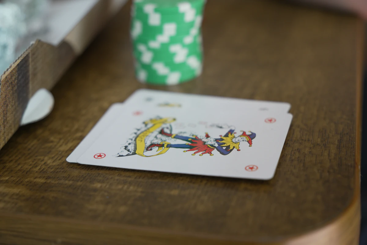 Kartu remi termasuk joker di atas meja kayu