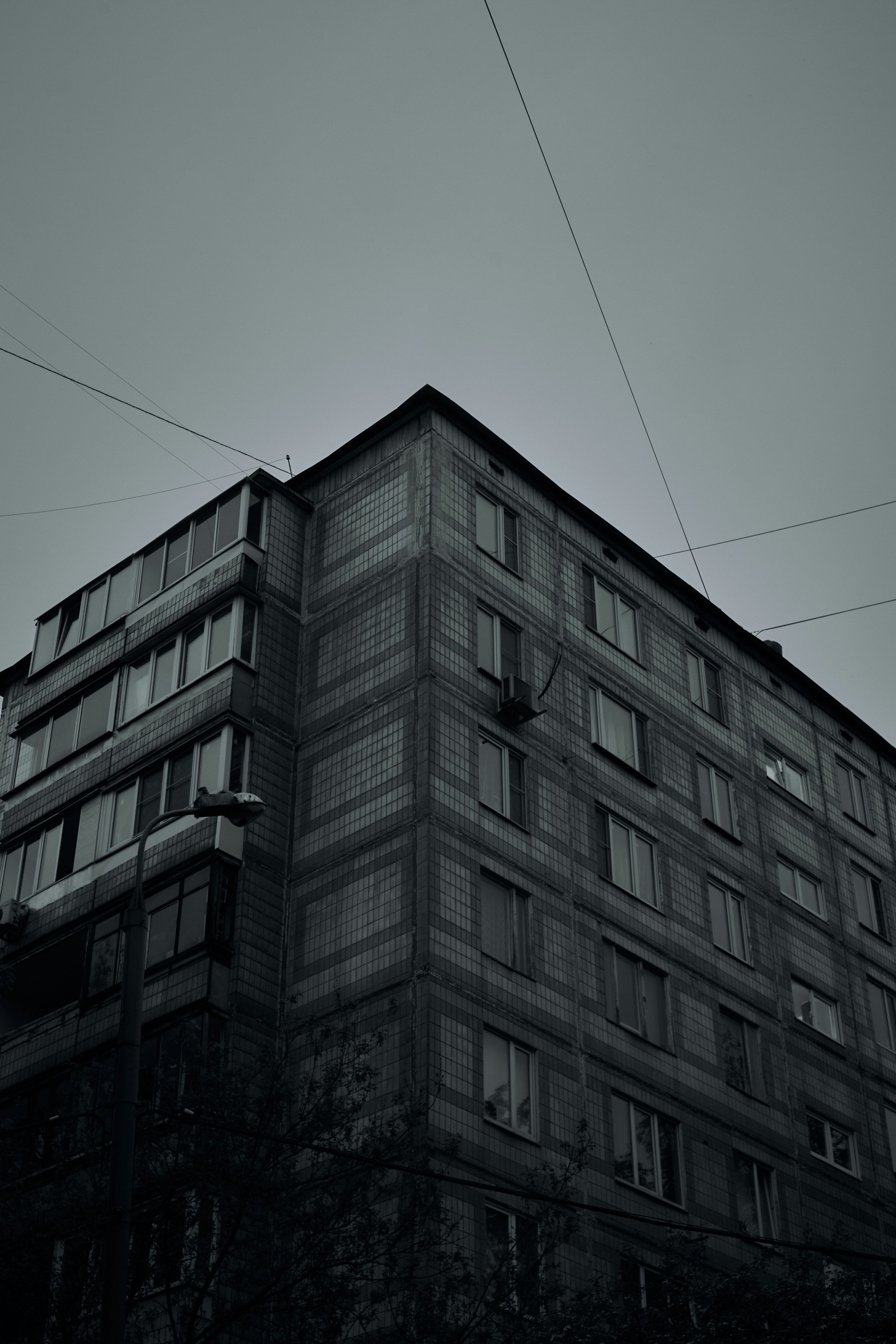Old concrete apartment building against a grey sky.