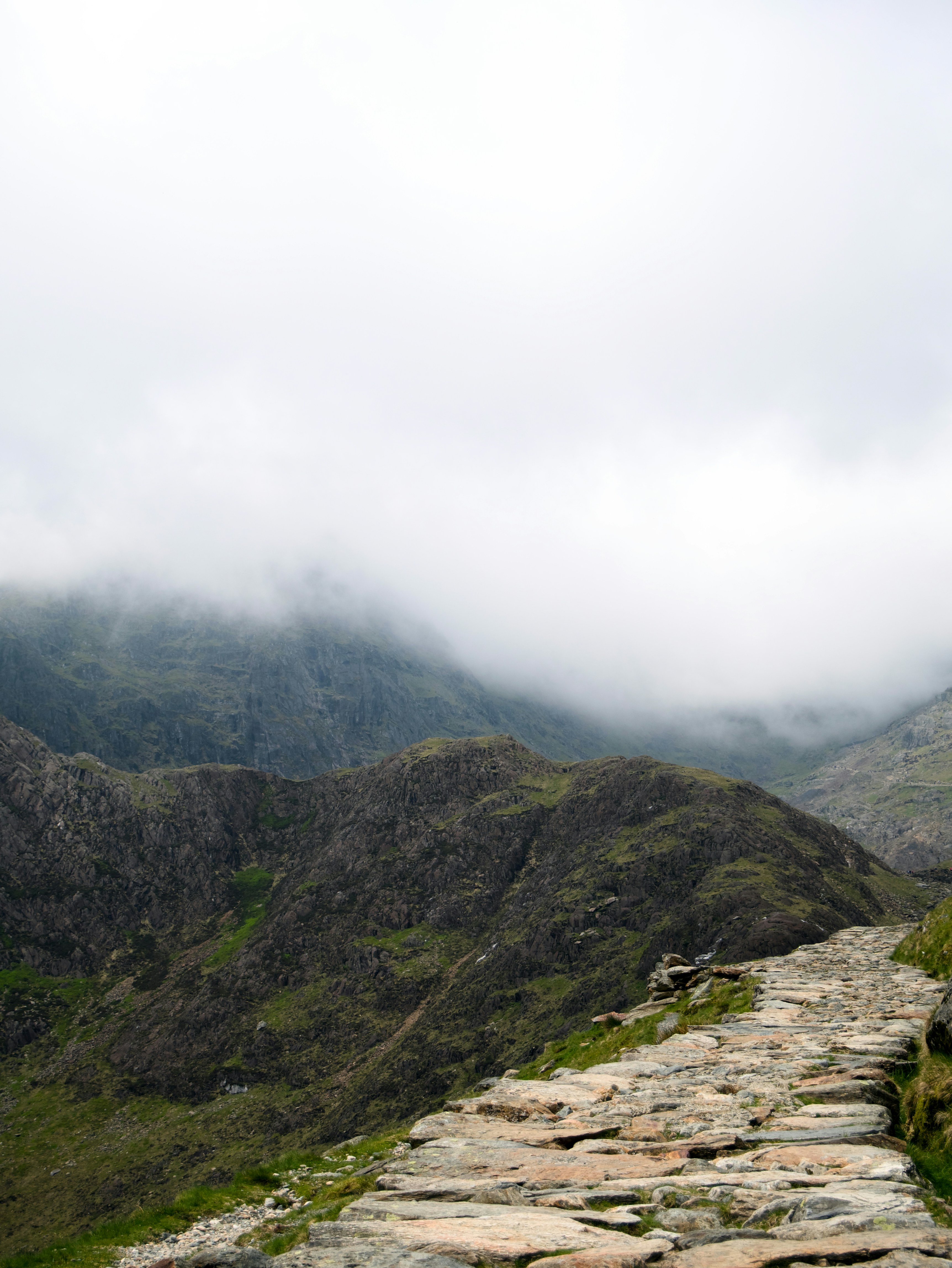 A stone path winding through foggy mountains.