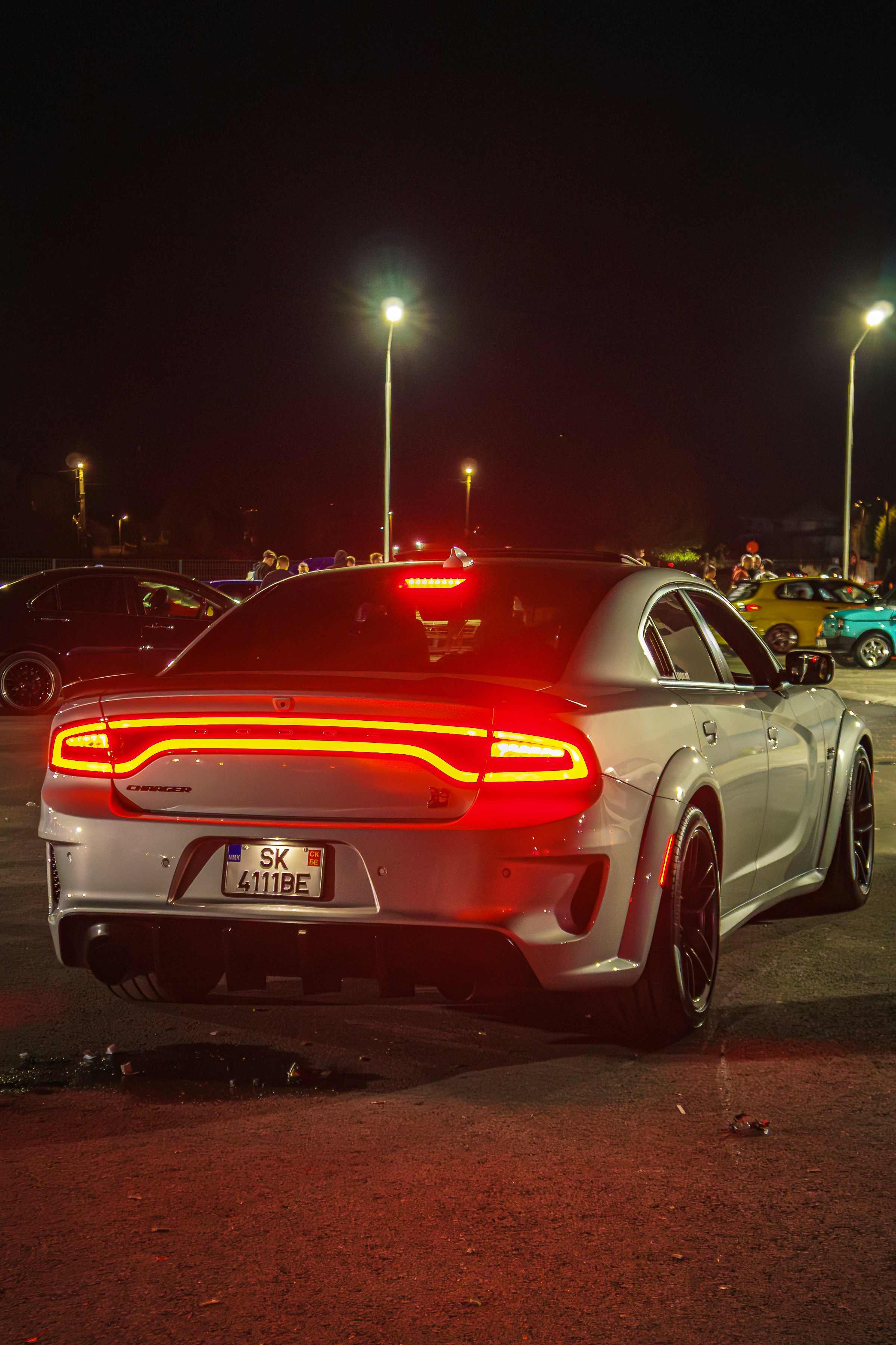 Silver dodge charger with illuminated taillights at night