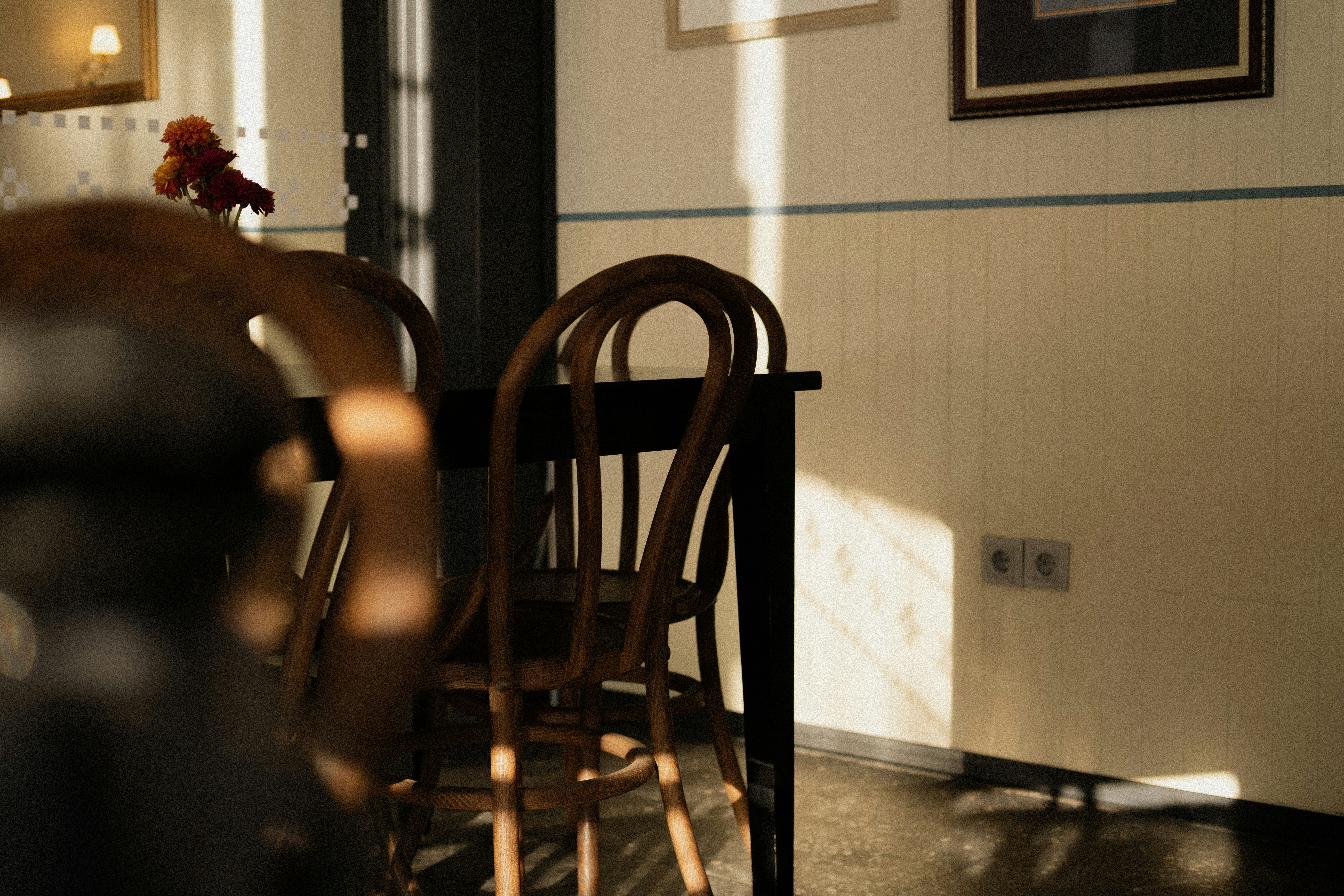 Holzstühle und ein Tisch, der in warmes Sonnenlicht getaucht war.