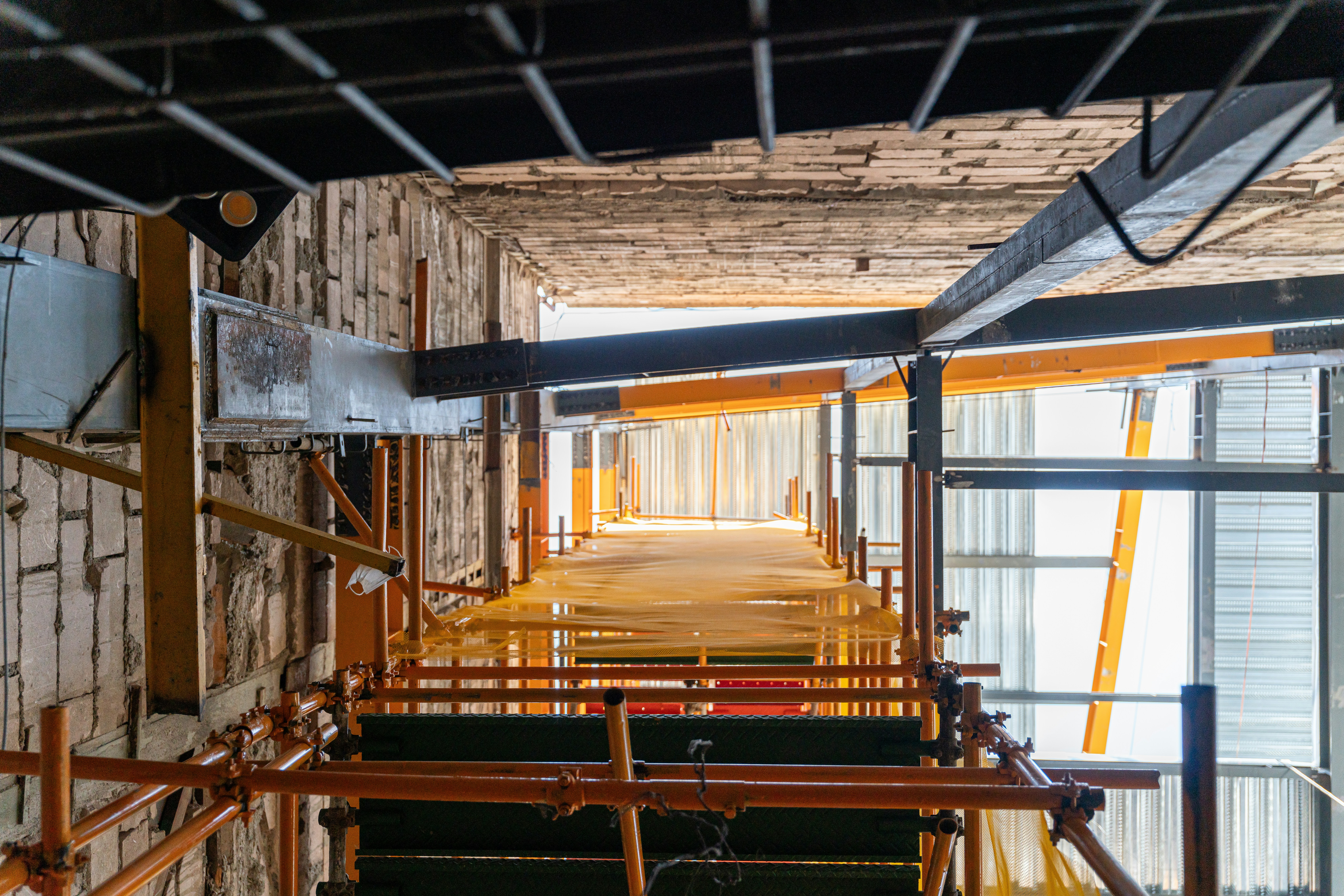 Long corridor of scaffolding within a building under construction.