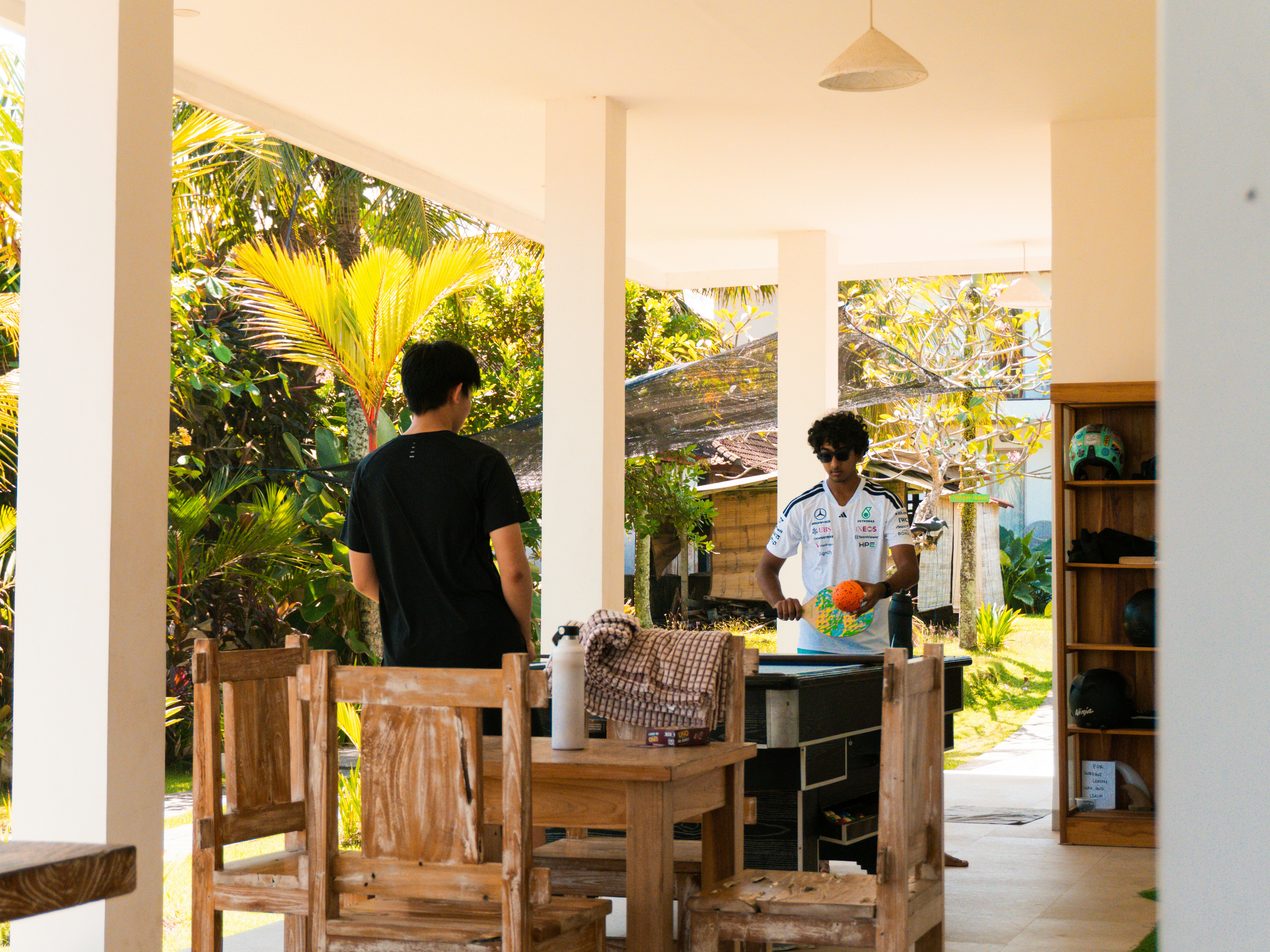 open house interior with visitors - Two men on a sunny outdoor patio with lush greenery