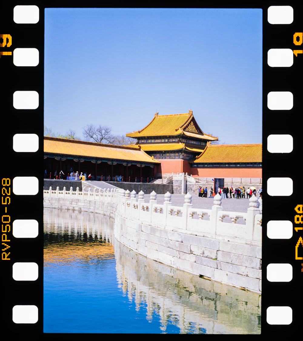 An ancient Chinese palace with golden roofs reflected in water, Beijing
