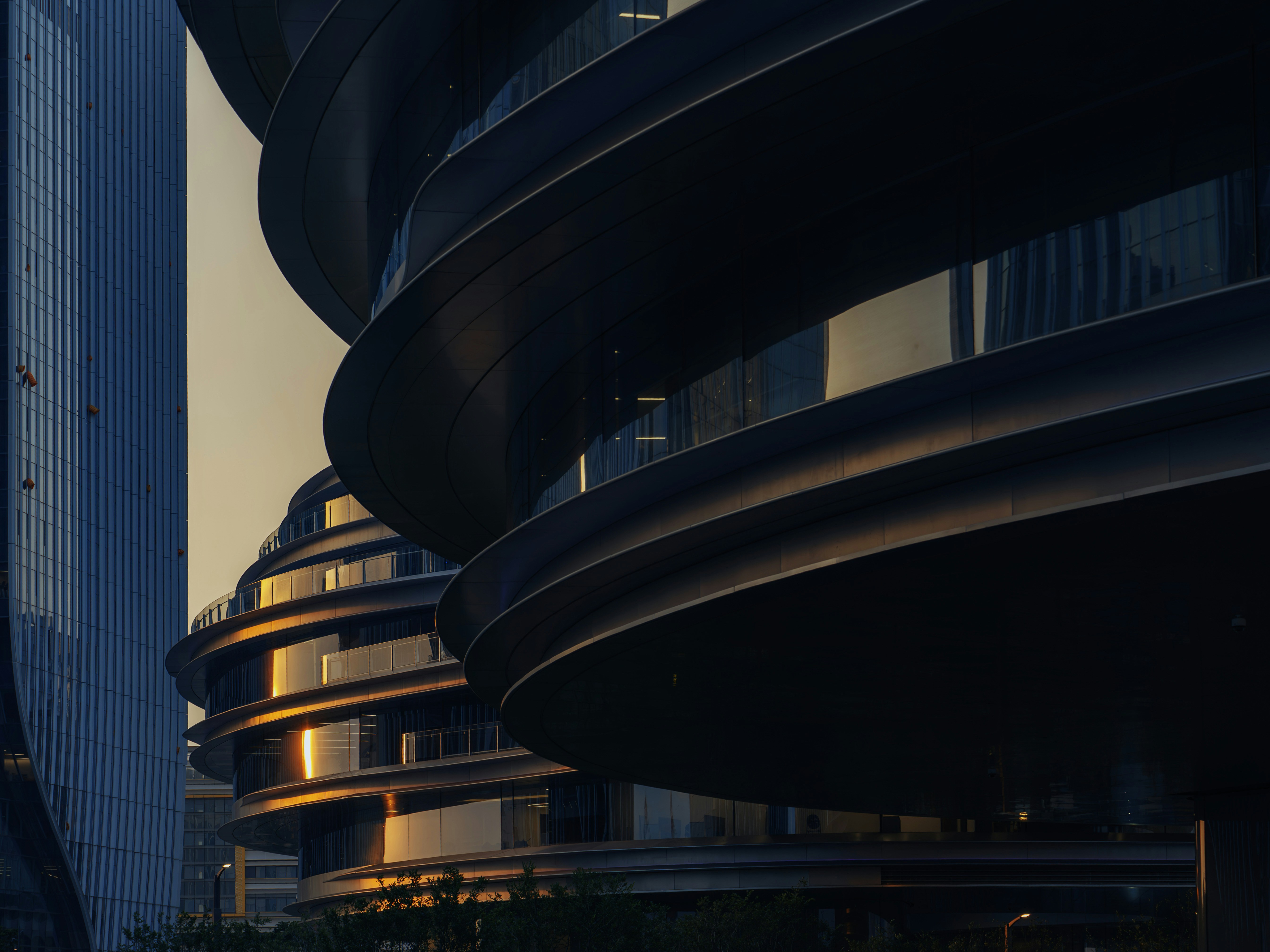 Modern curved buildings with golden reflections in an urban setting.