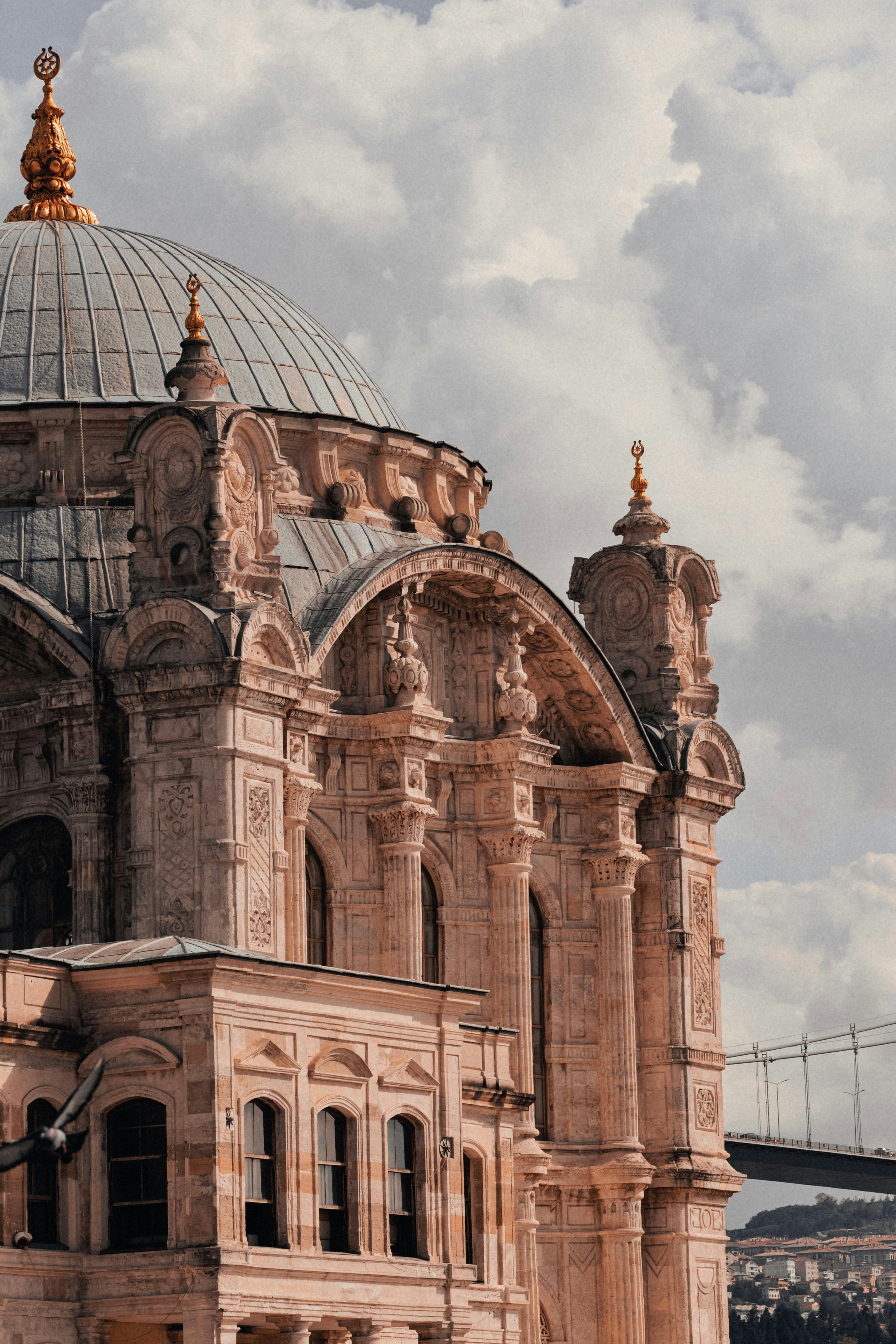 Ornate mosque dome and facade against a cloudy sky