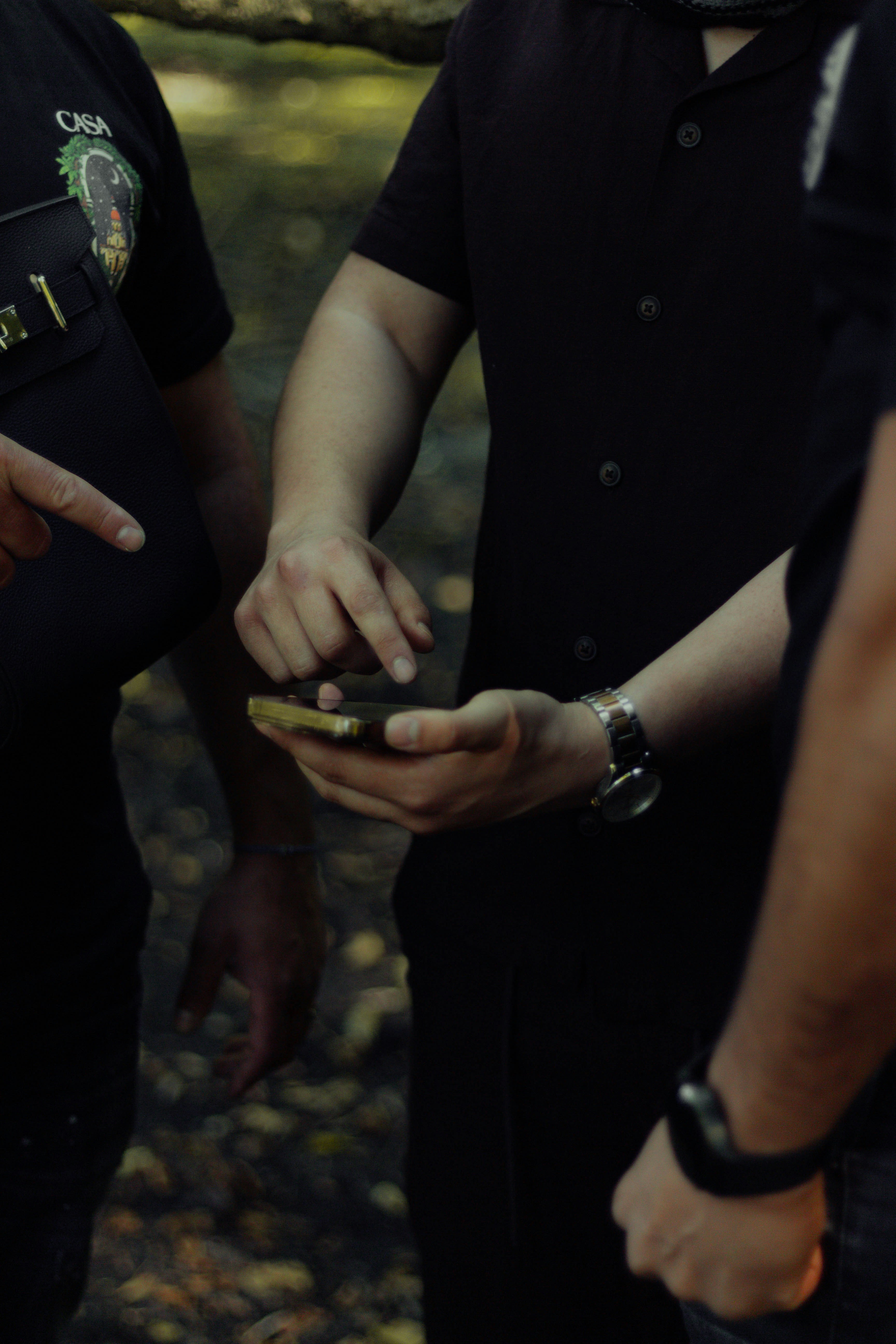 People examining a smartphone screen outdoors.