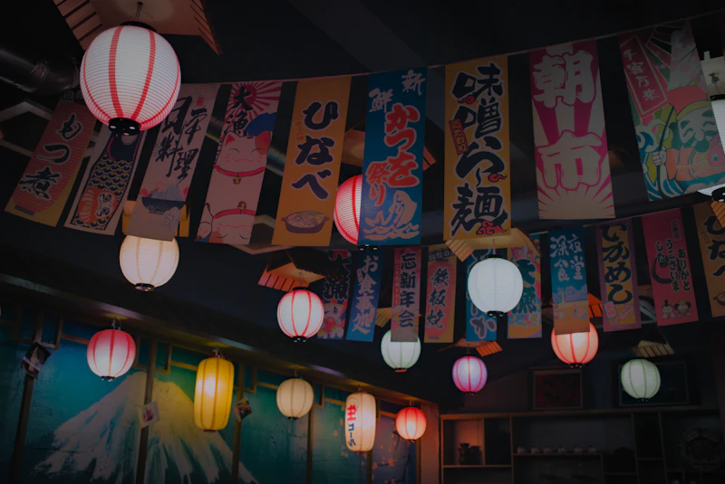 Izakaya interior in Tokyo — warm wood bar counter, paper lanterns, traditional Japanese dining atmosphere