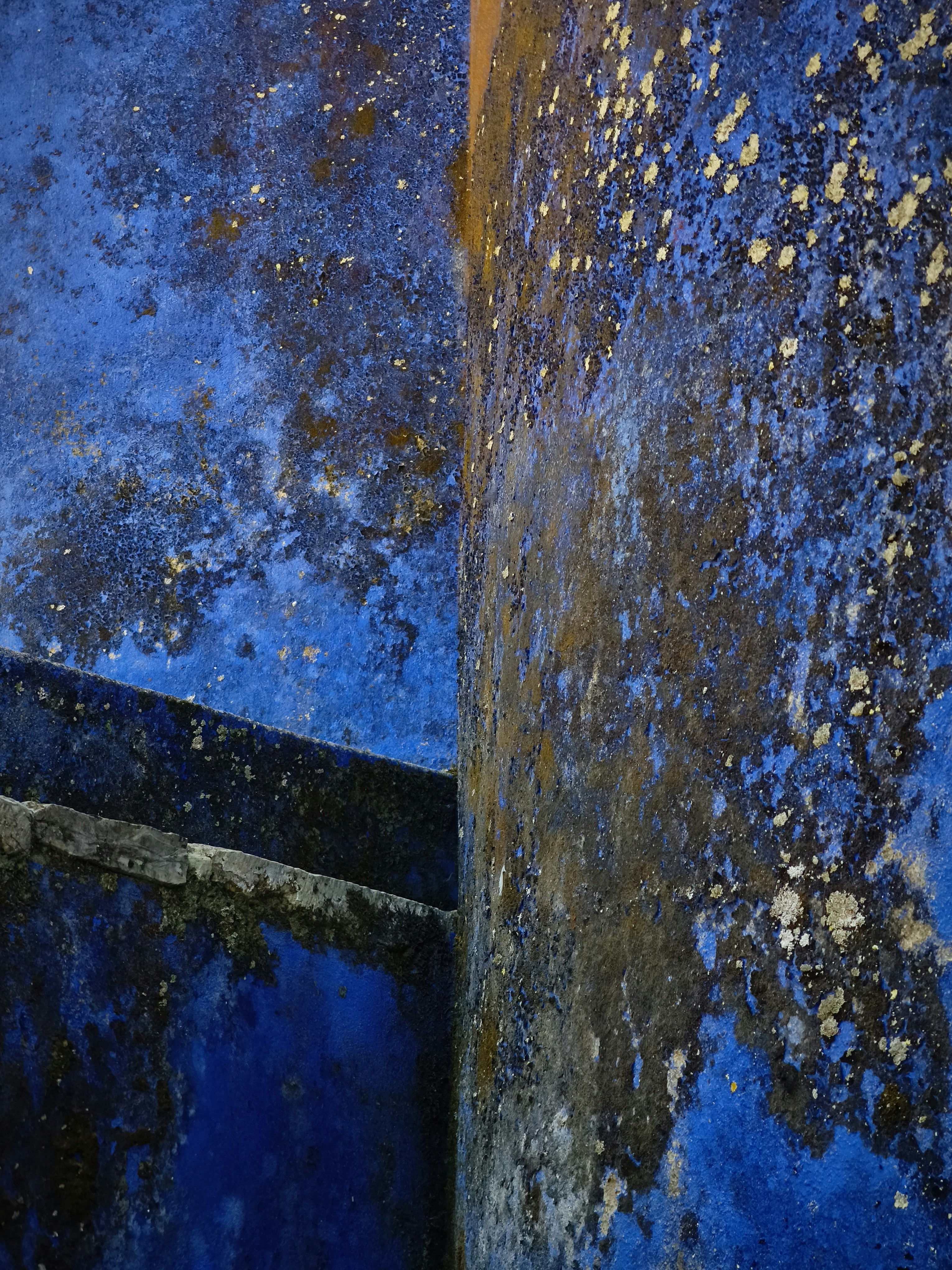 Texturierte blaue Wand mit weißen und dunklen Flecken