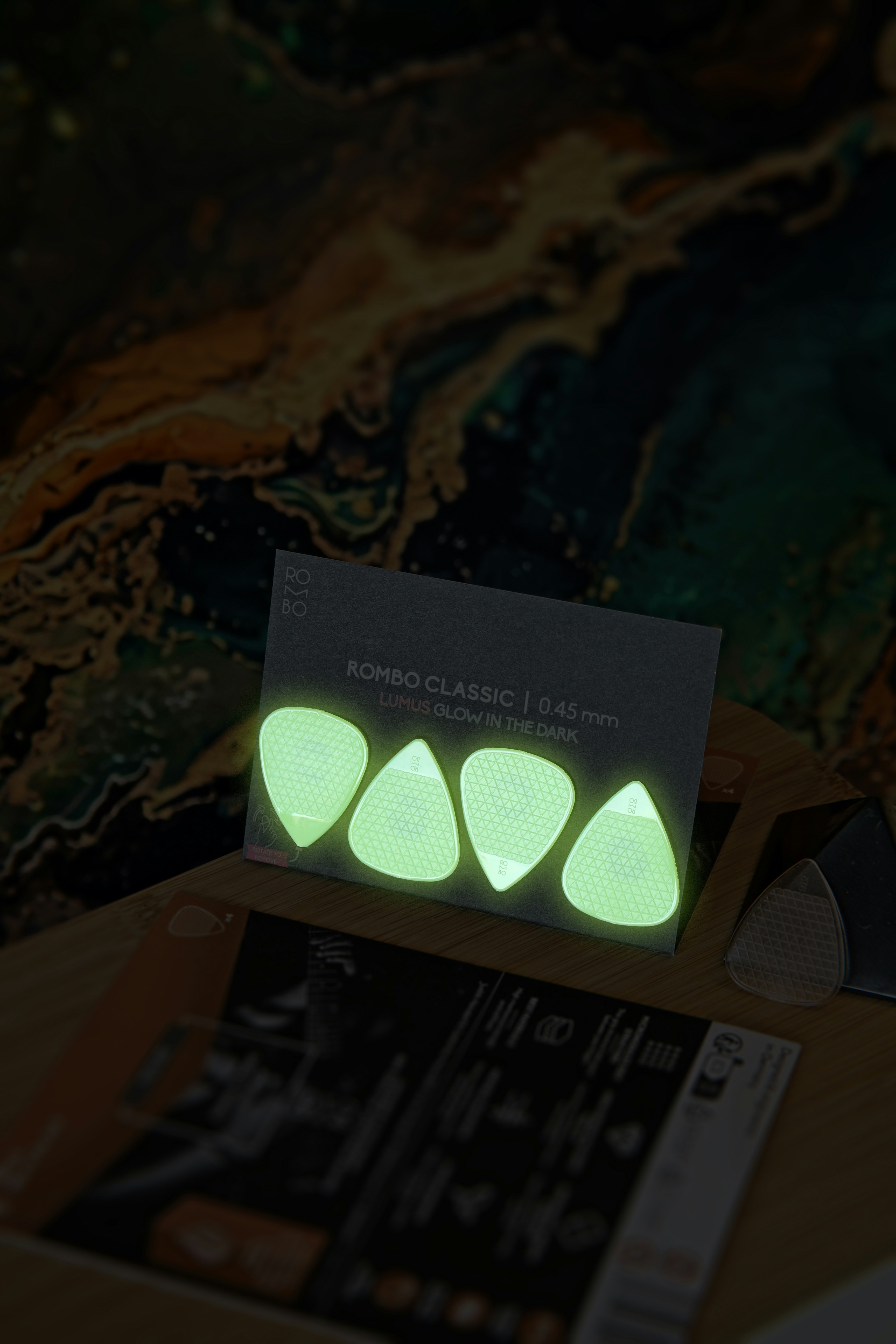 Quatre médiators verts lumineux sur une carte d’affichage.