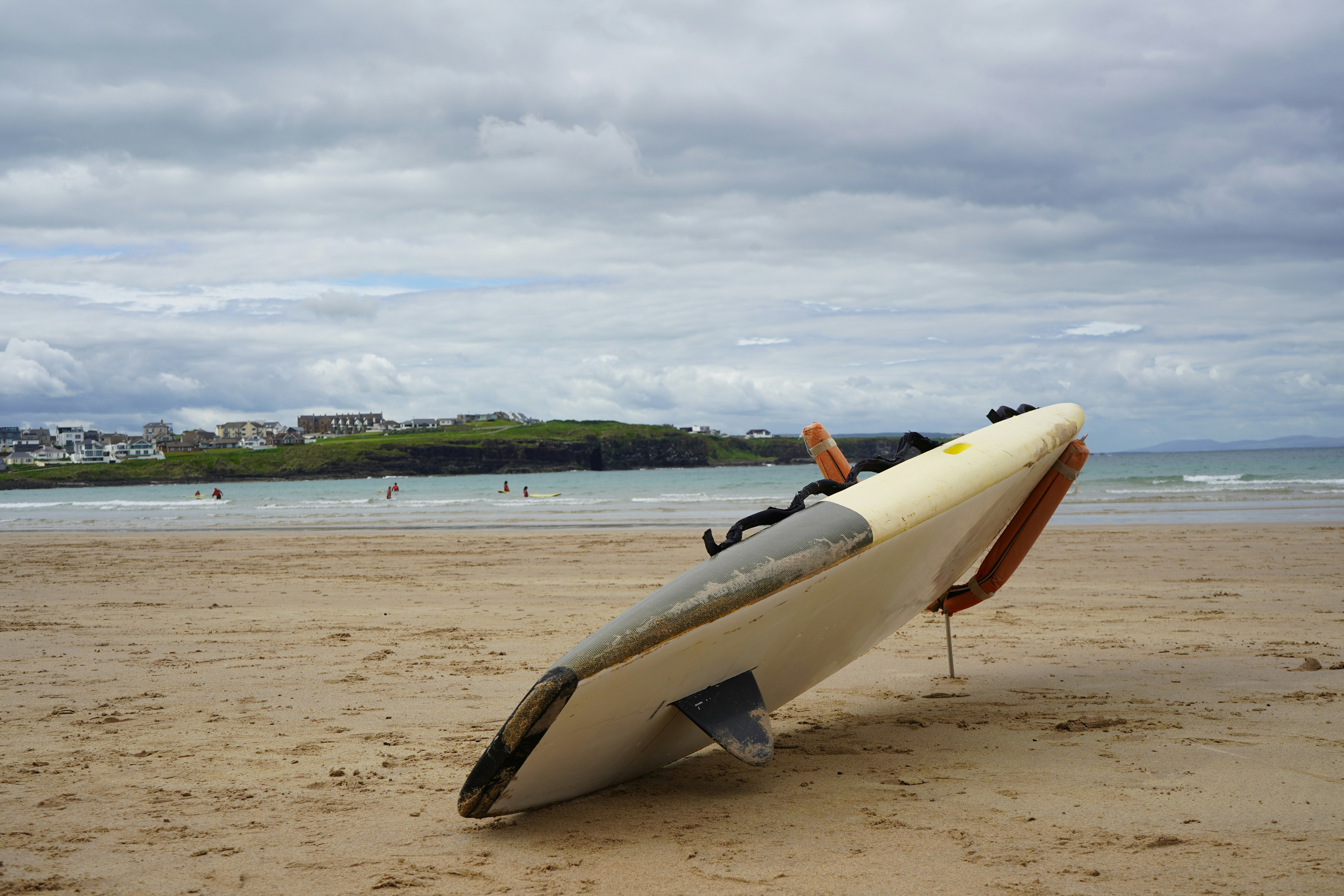 Lifeguard board on a sandy beach under a cloudy sky.
