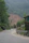 Winding road through green mountains with a visible landslide.